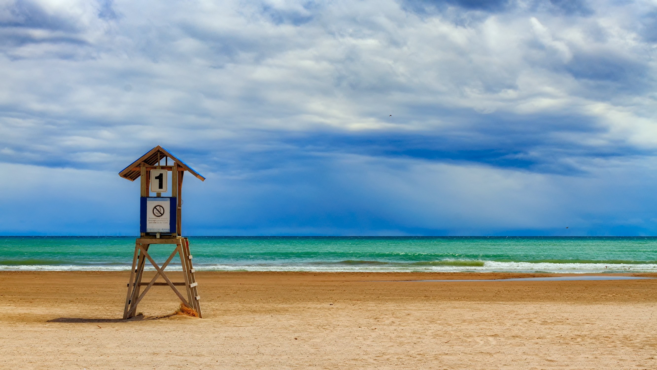 a lifeguard stand on a deserted beach along a green ocean under a blue sky, number one 4k, HD Wallpaper