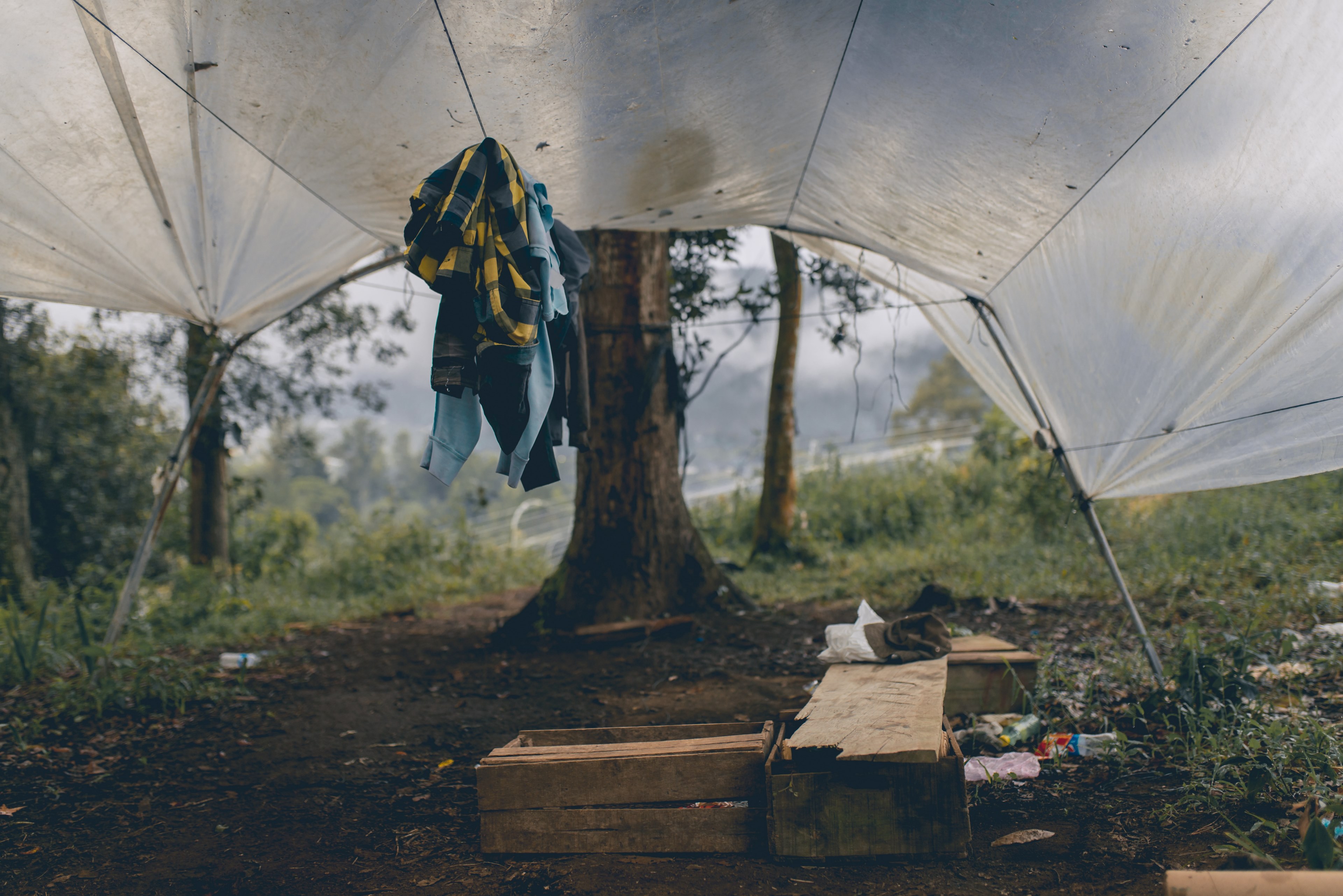 a tent filled with clothing wood and empty plastic bottles, tent and supplies 4k, HD Wallpaper