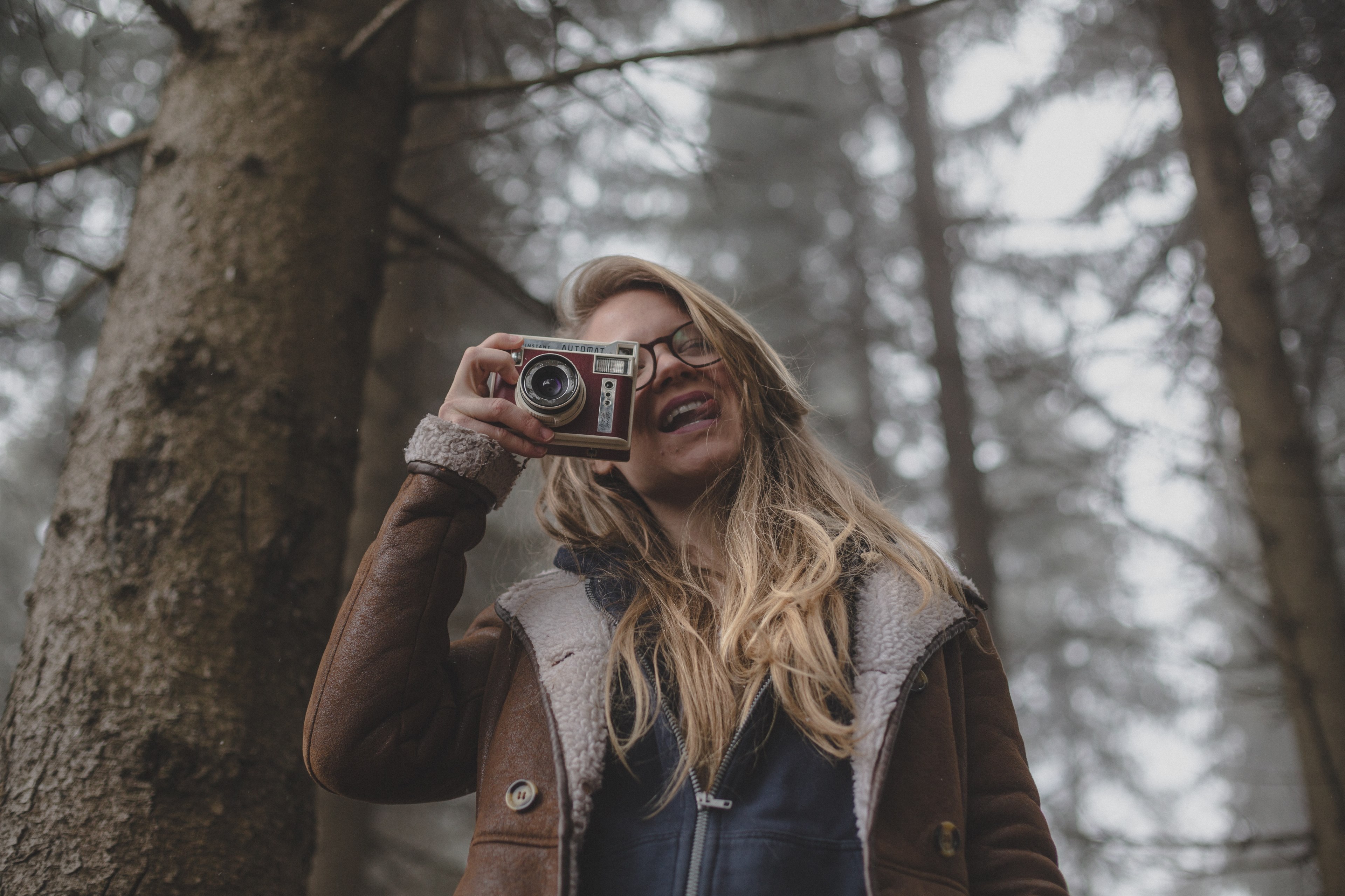 smiling woman in glasses and coat takes a photo in a forest, girl with the camera 4k, HD Wallpaper