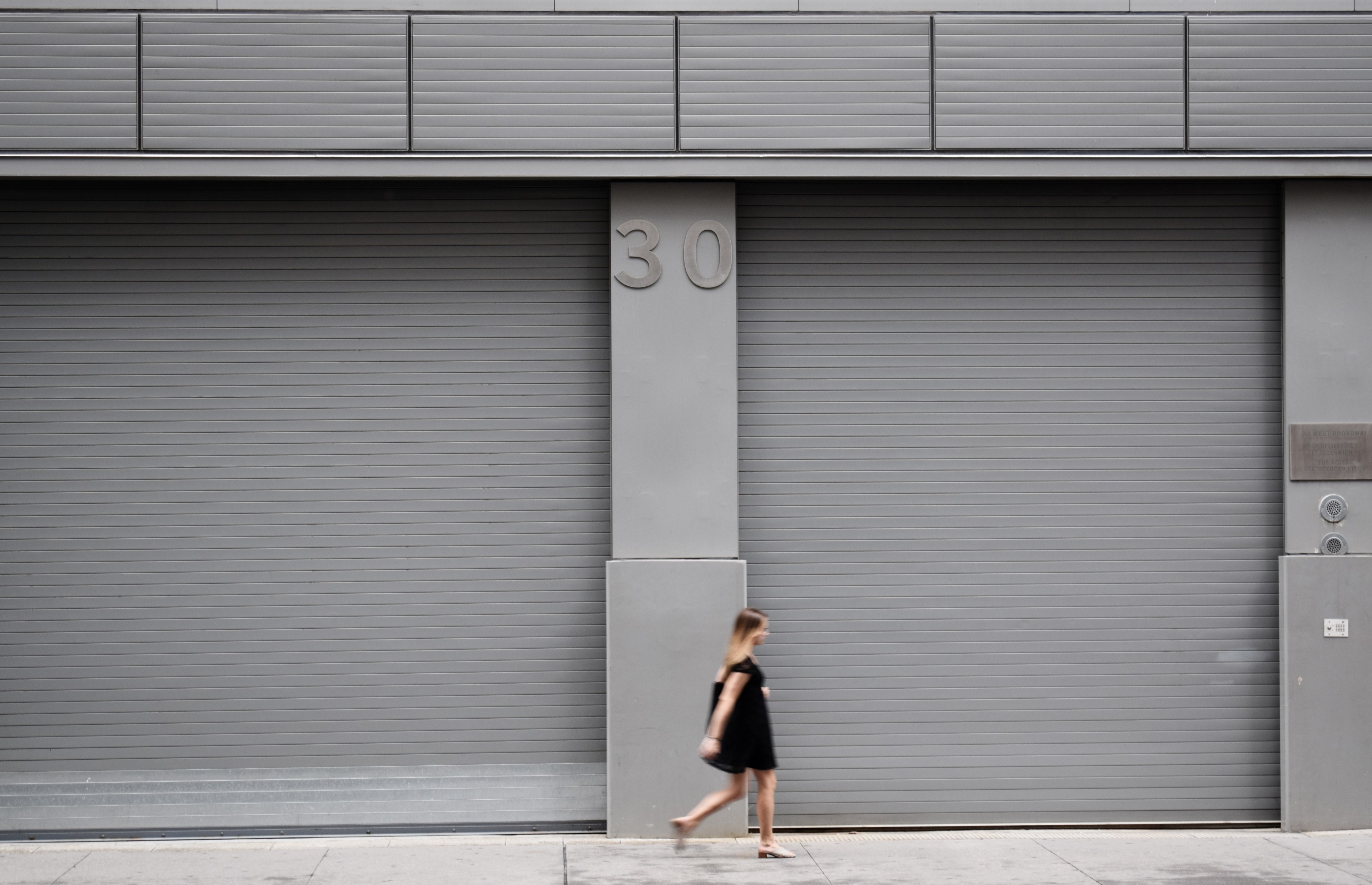 a woman walks along a gray colored building with the number 30, _woman gray building 30 4k, HD Wallpaper