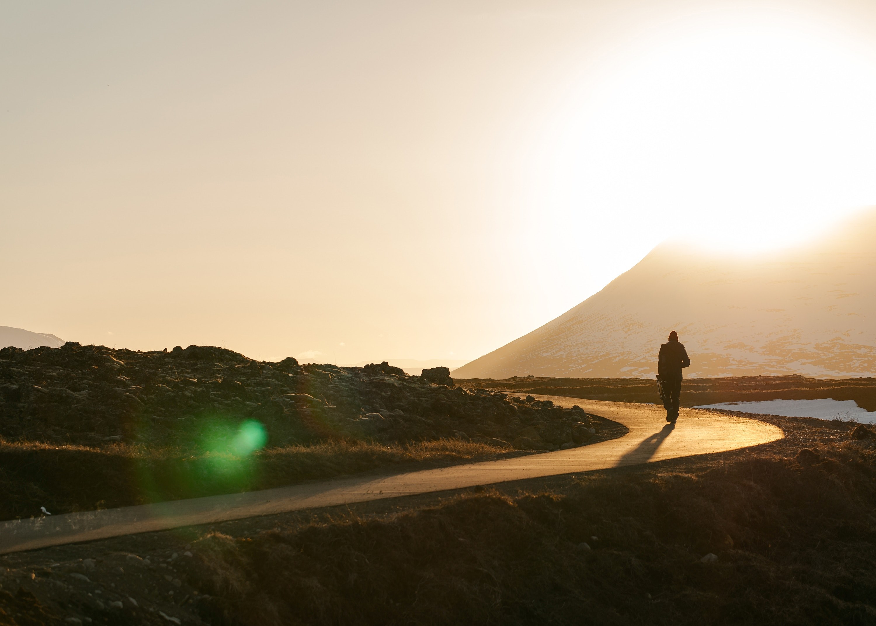 a silhouette of a person walking on a pathway during a sunset in gafoss, golden road 4k, HD Wallpaper