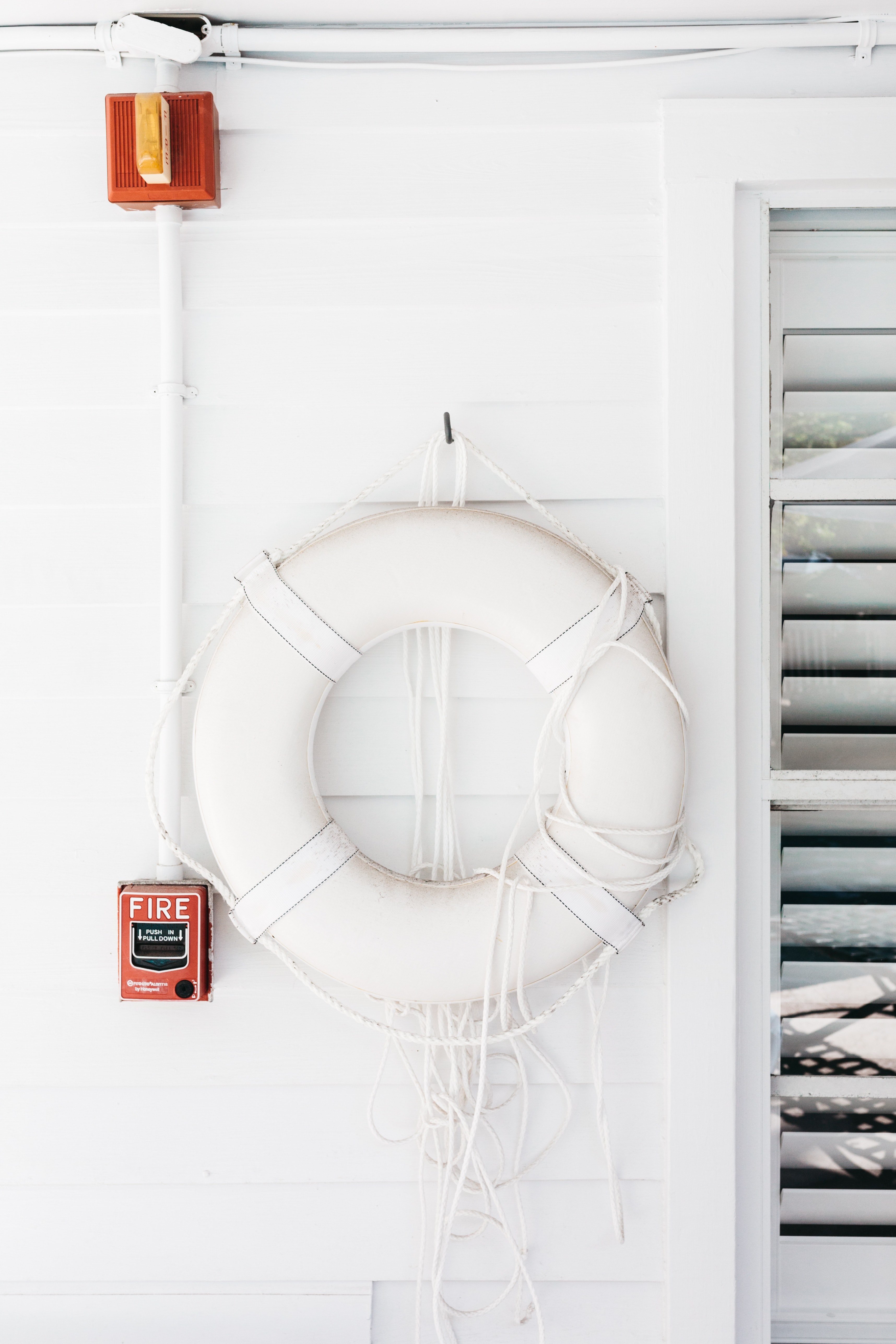 a white life belt on a white wooden wall next to a window, life belt_ 4k, Phone HD Wallpaper