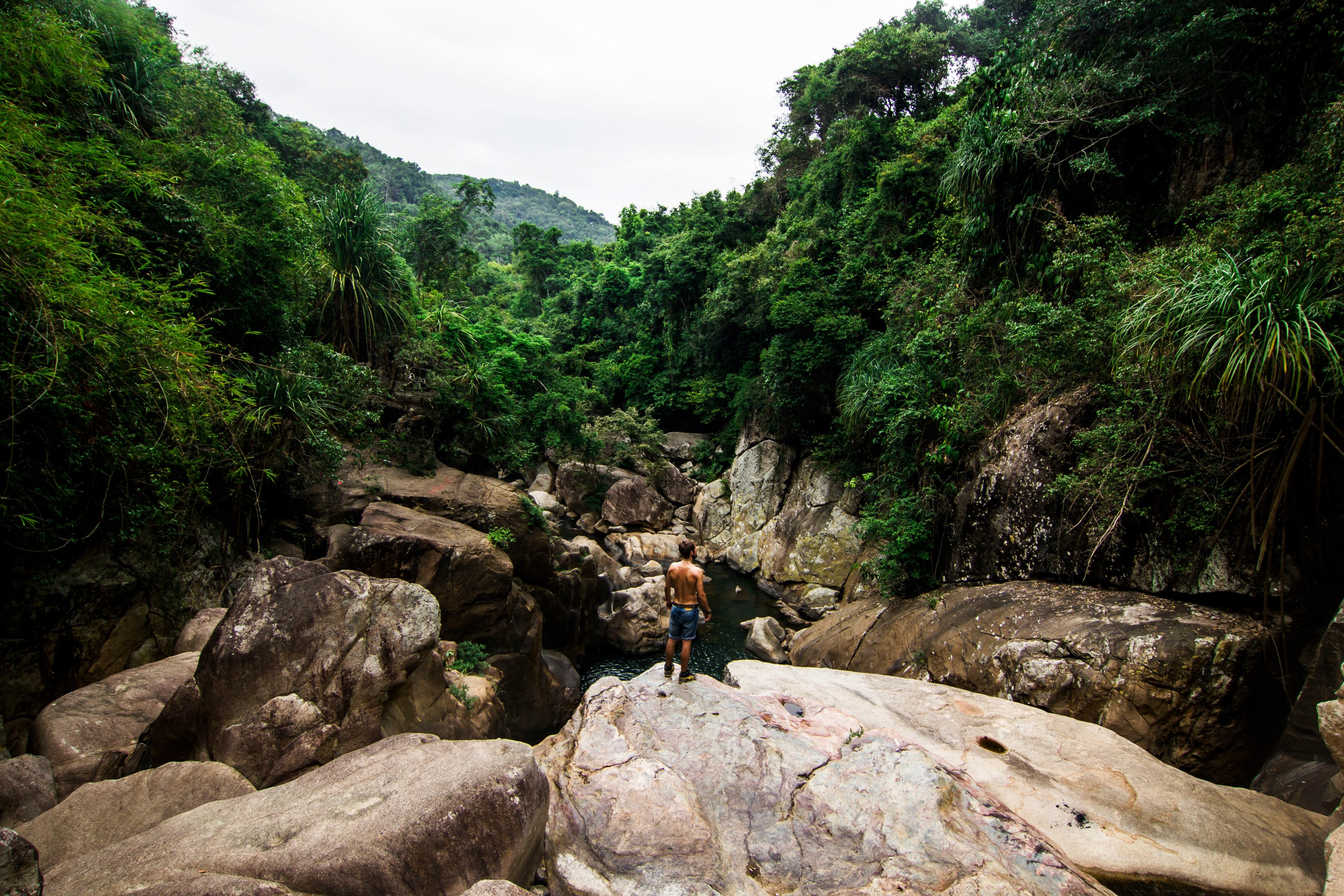 a shirtless man on smooth rocks overlooking a river in vietnam, shirtless man over a river 4k, HD Wallpaper