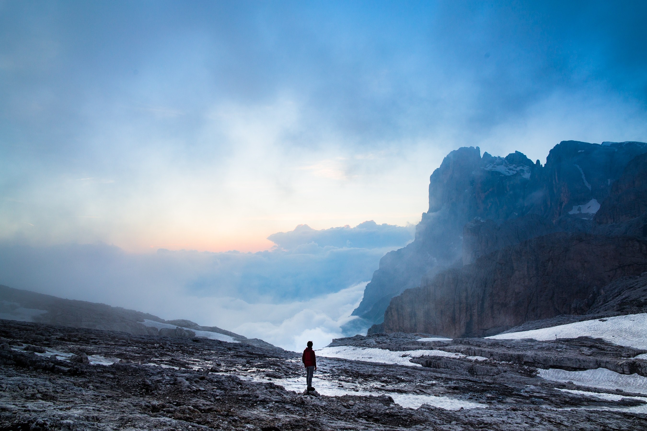 a lone hiker standing on a rock on a mountain slope covered with patches of snow, hiker on a snowy slope 4k, HD Wallpaper