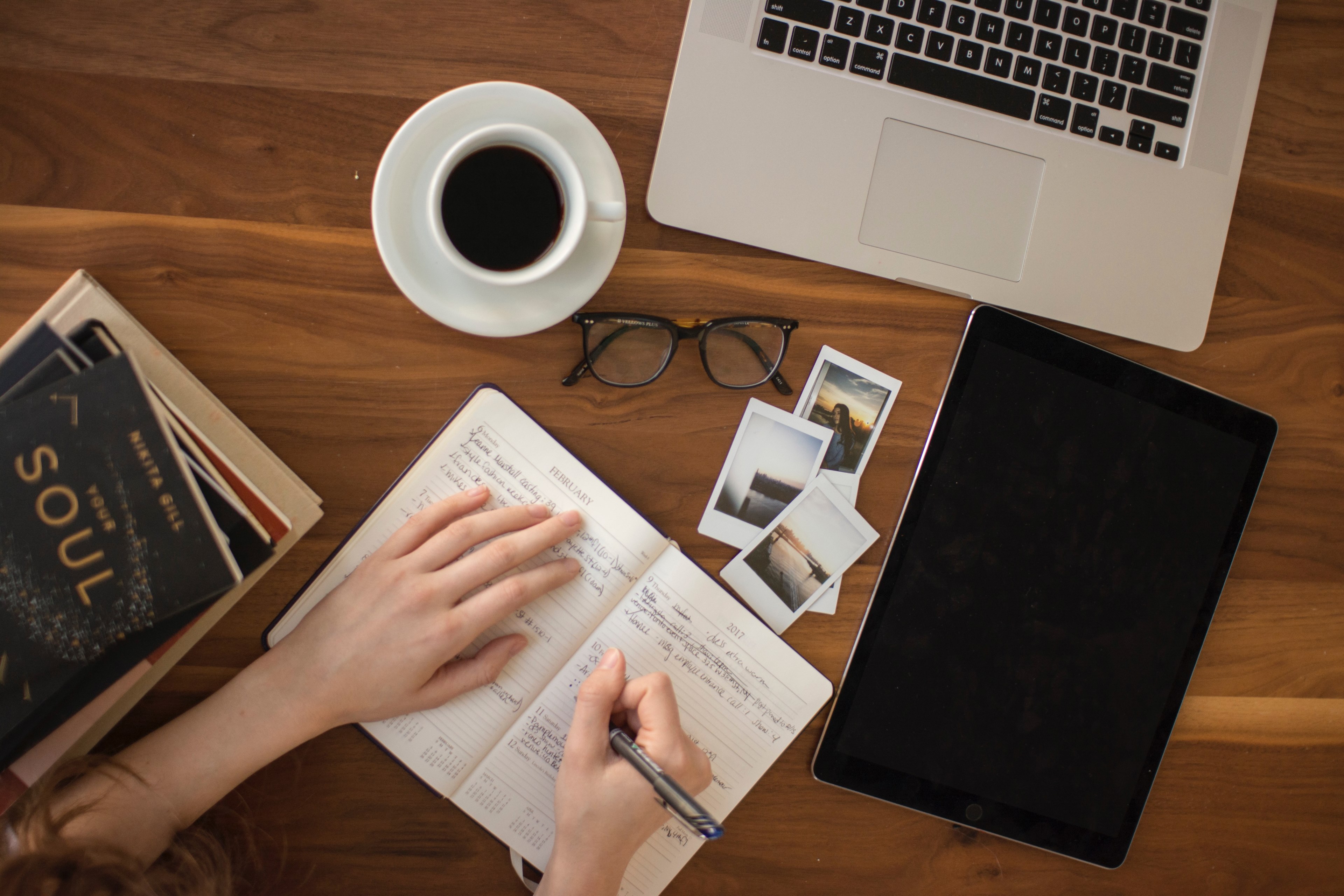 an overhead short of a woman writing in a journal at a busy table with a cup of coffee, journaling over coffee 4k, HD Wallpaper