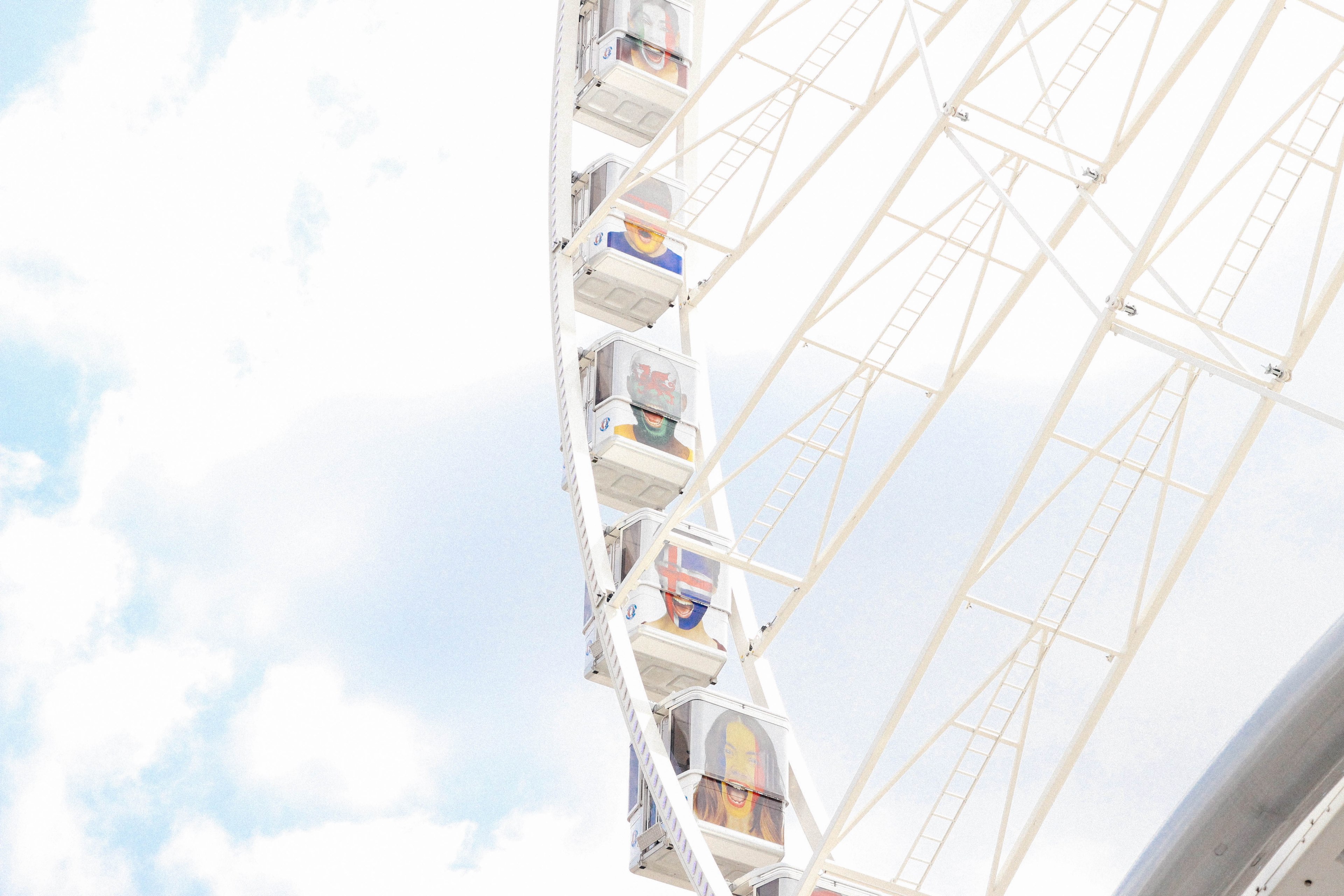 a white ferris wheel with passenger cars painted with different faces on them in paris, ferris wheel with flag faces 4k, HD Wallpaper