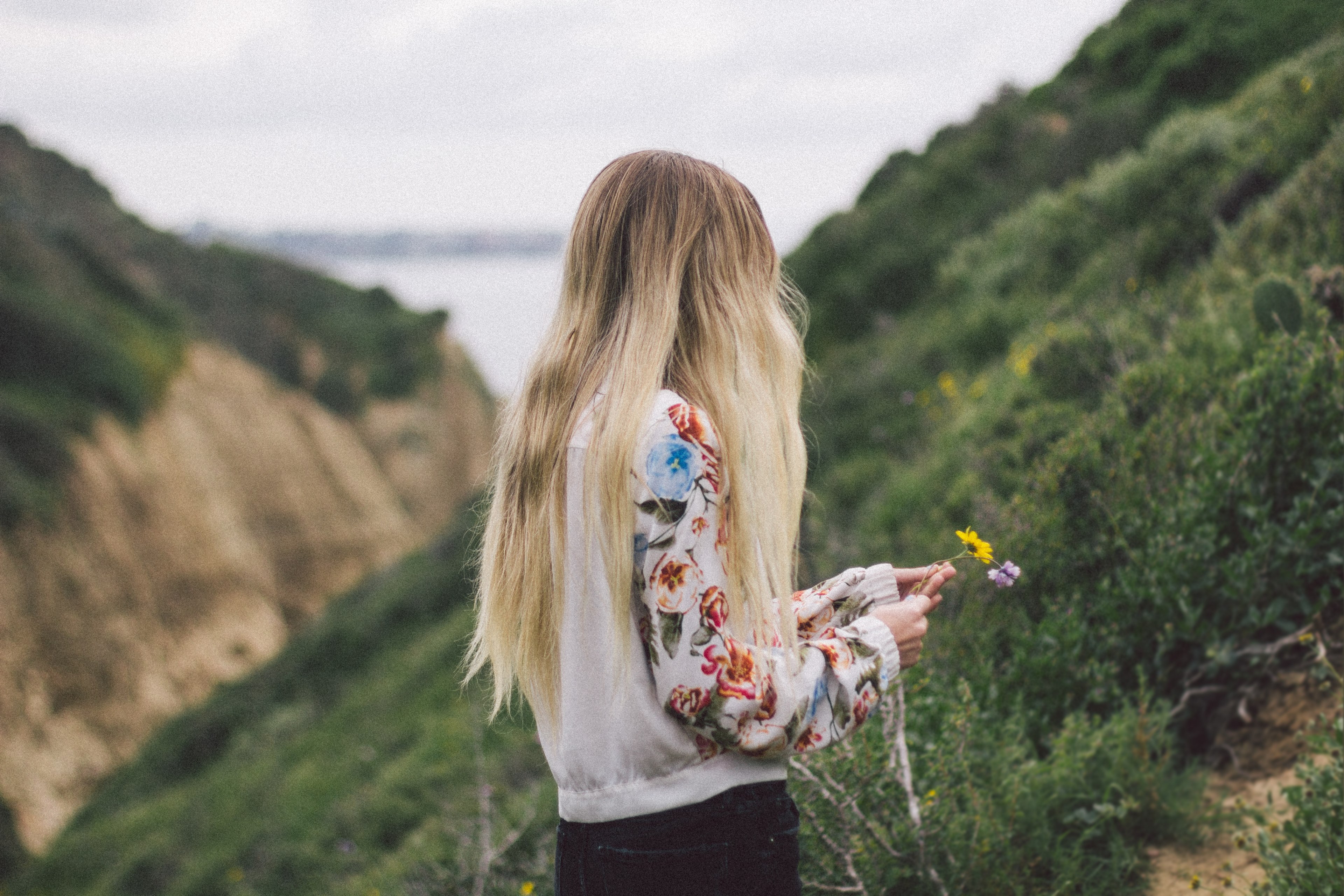 a blonde woman picking flowers on a grassy slope, blonde woman picking flowers 4k, HD Wallpaper