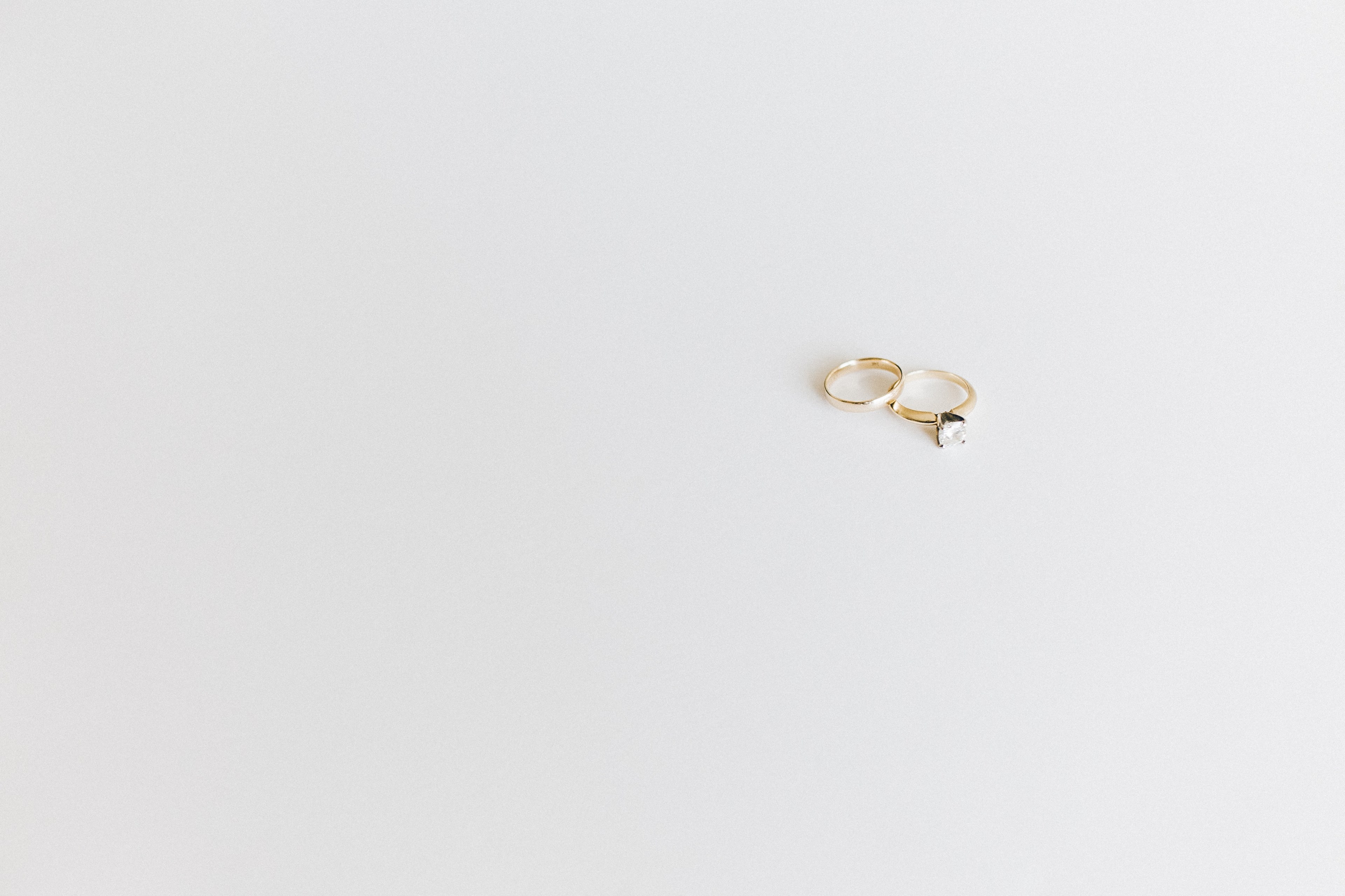 delicate gold wedding rings sit on a minimalist white surface, wedding rings on white surface 4k, HD Wallpaper