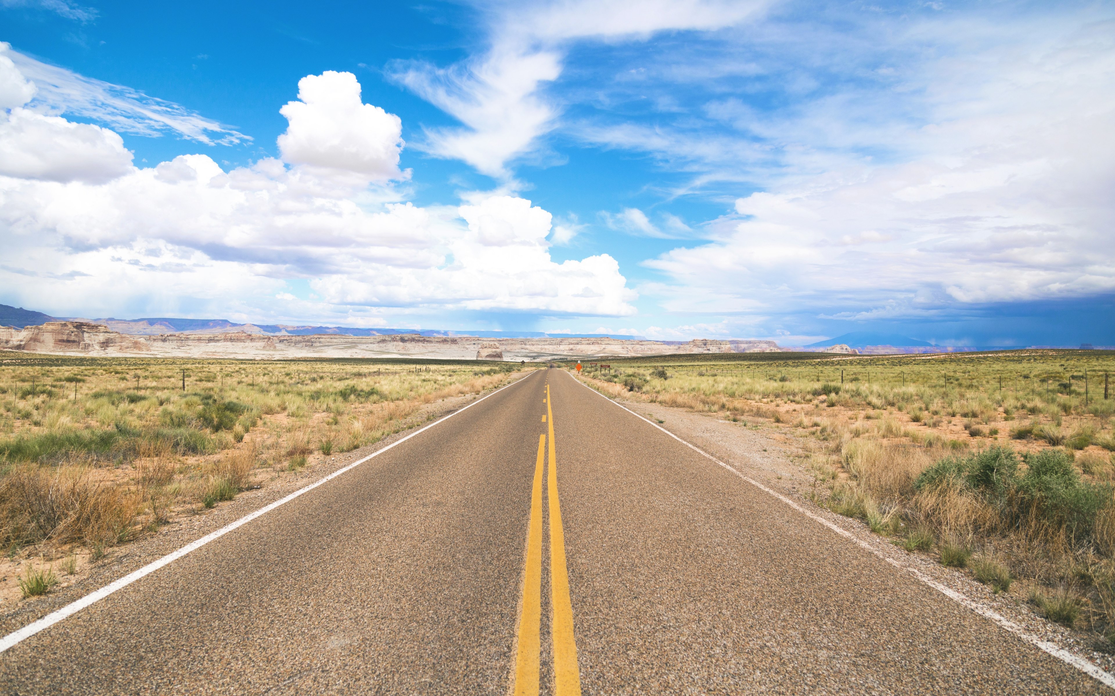 a rural highway surrounded by a desert and meadow with a blue sky filled with fluffy clouds, ready to roadtrip 4k, HD Wallpaper