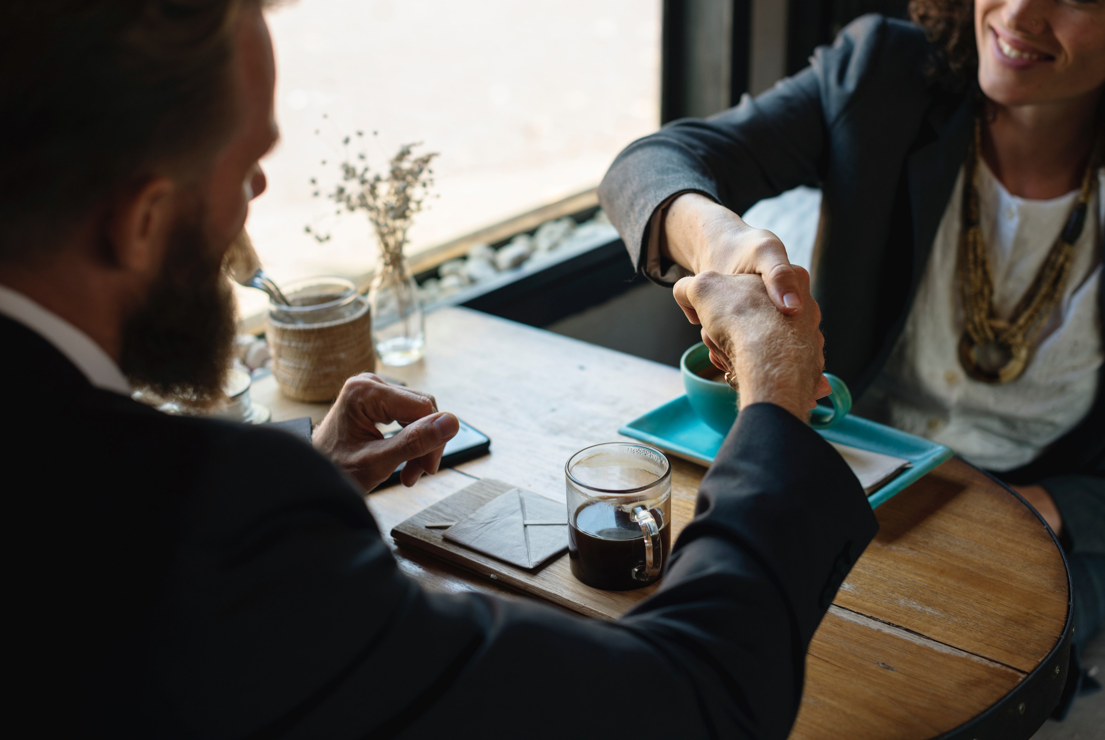 a man and a woman shaking hands over coffee at a coffee shop, lets shake on this 4k, HD Wallpaper