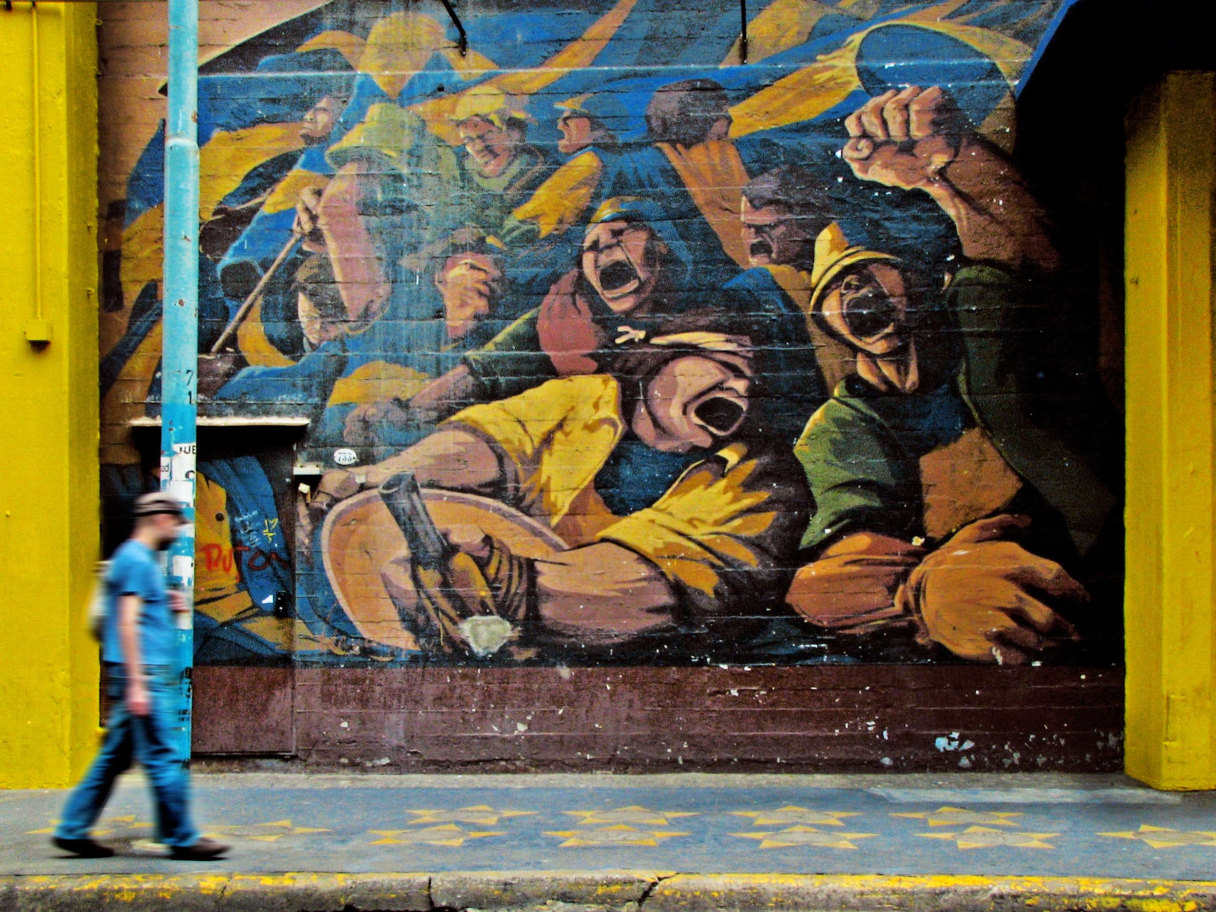 man walking on sidewalk with lamppost in front of graffiti of passionate workers la boca, paredes que gritan_ 4k, HD Wallpaper