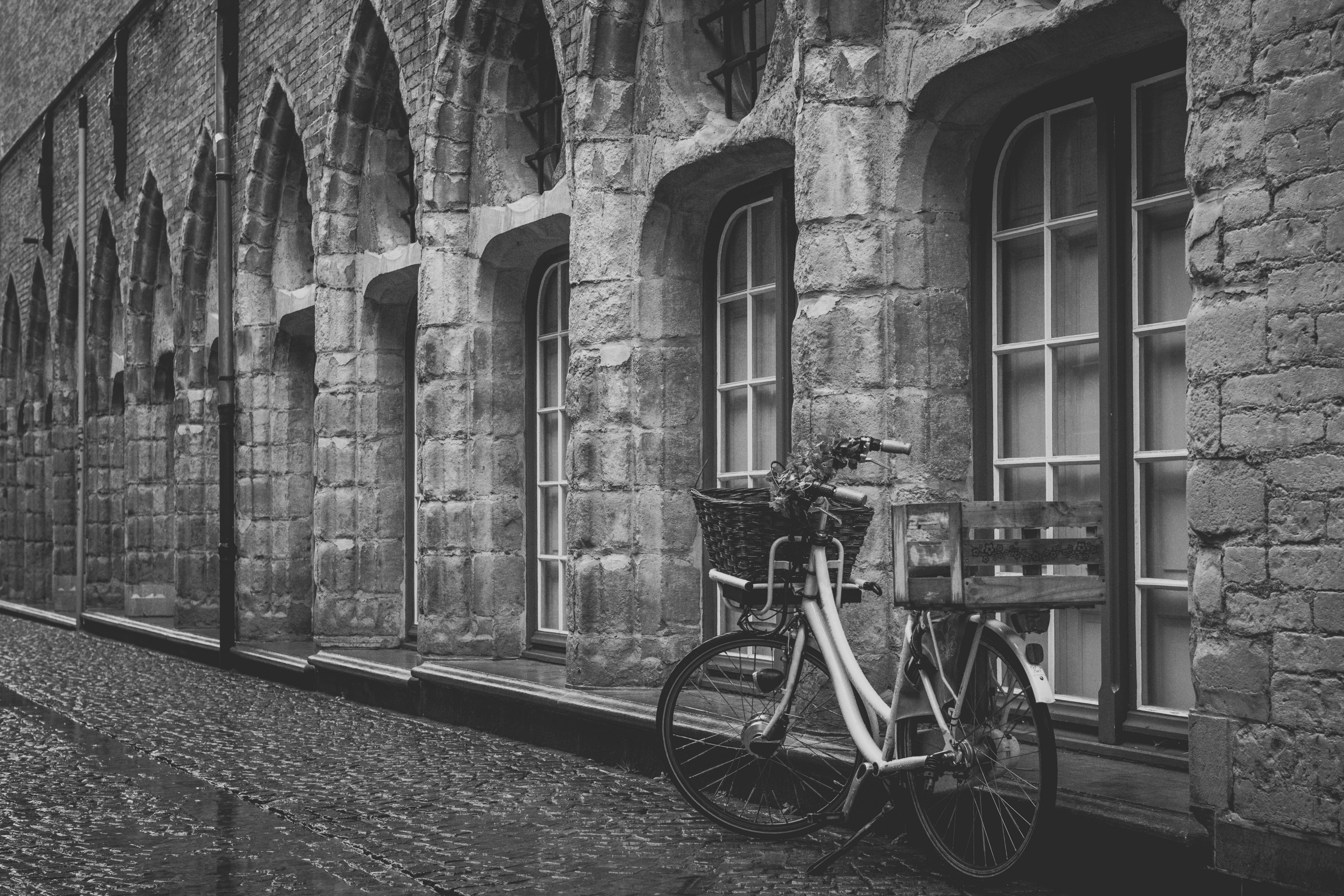 black and white shot of bike with basket parked on cobbled pavement near windows, bike on cobbled street 4k, HD Wallpaper