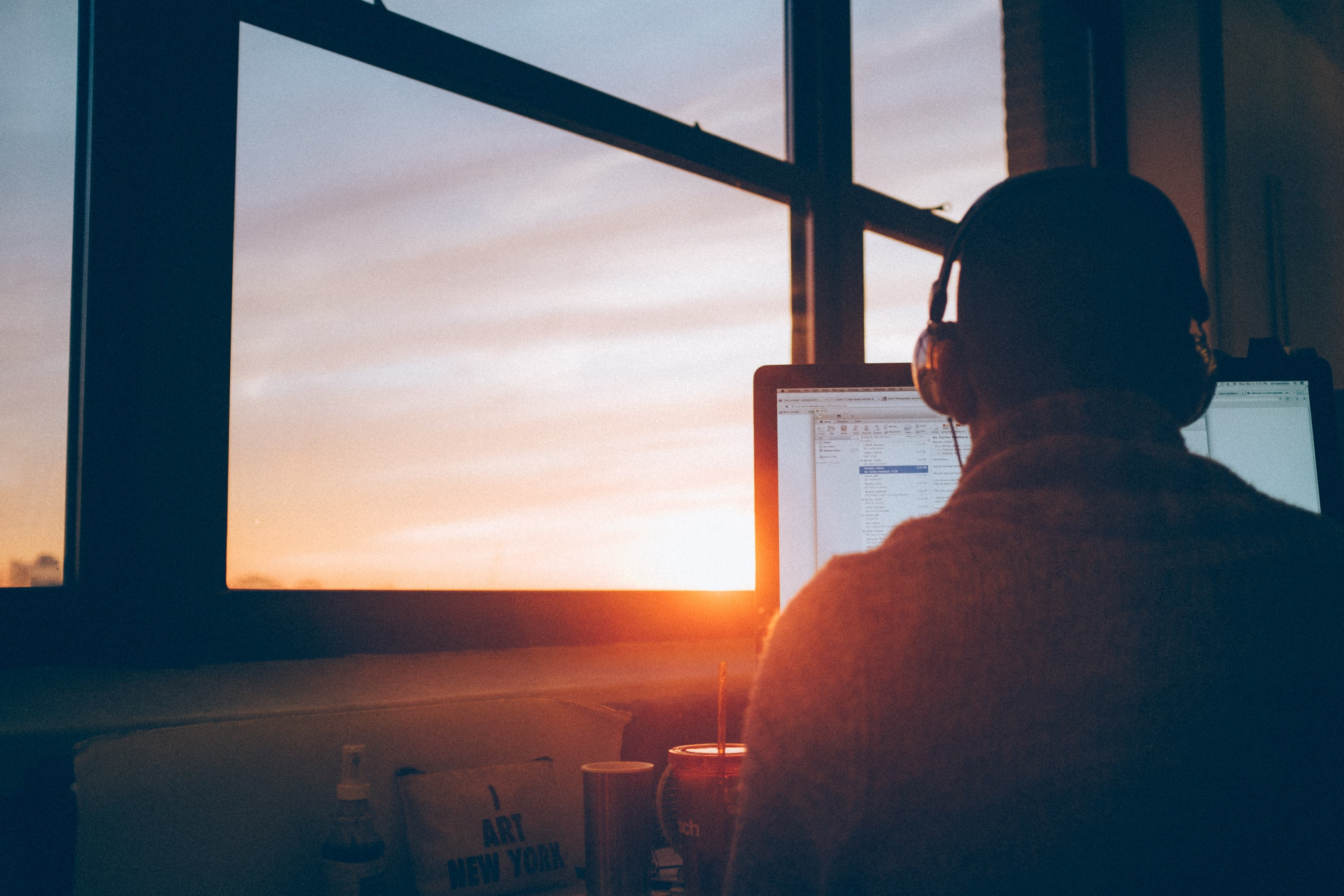 man wearing headphones at desk with window view of sunset in background, view 4k, HD Wallpaper
