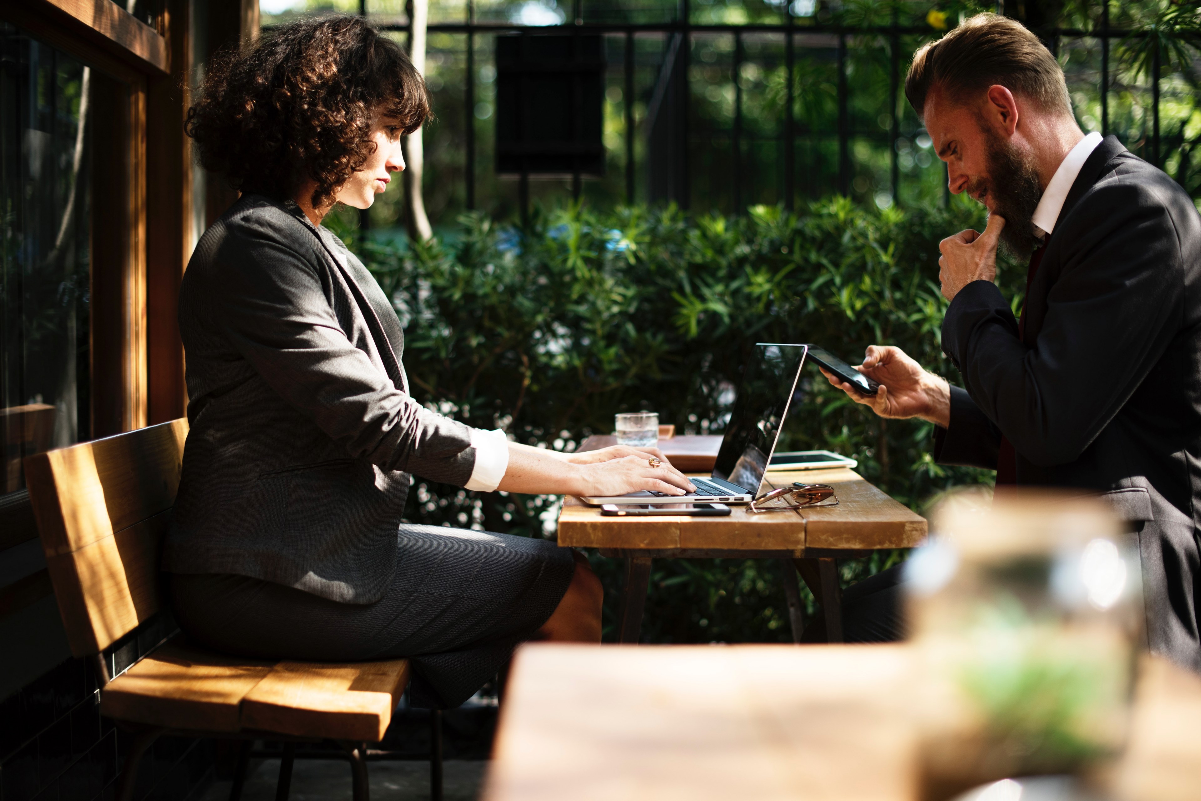 two people in business attire sitting at an outdoor table with electronic devices, connected businesspeople 4k, HD Wallpaper