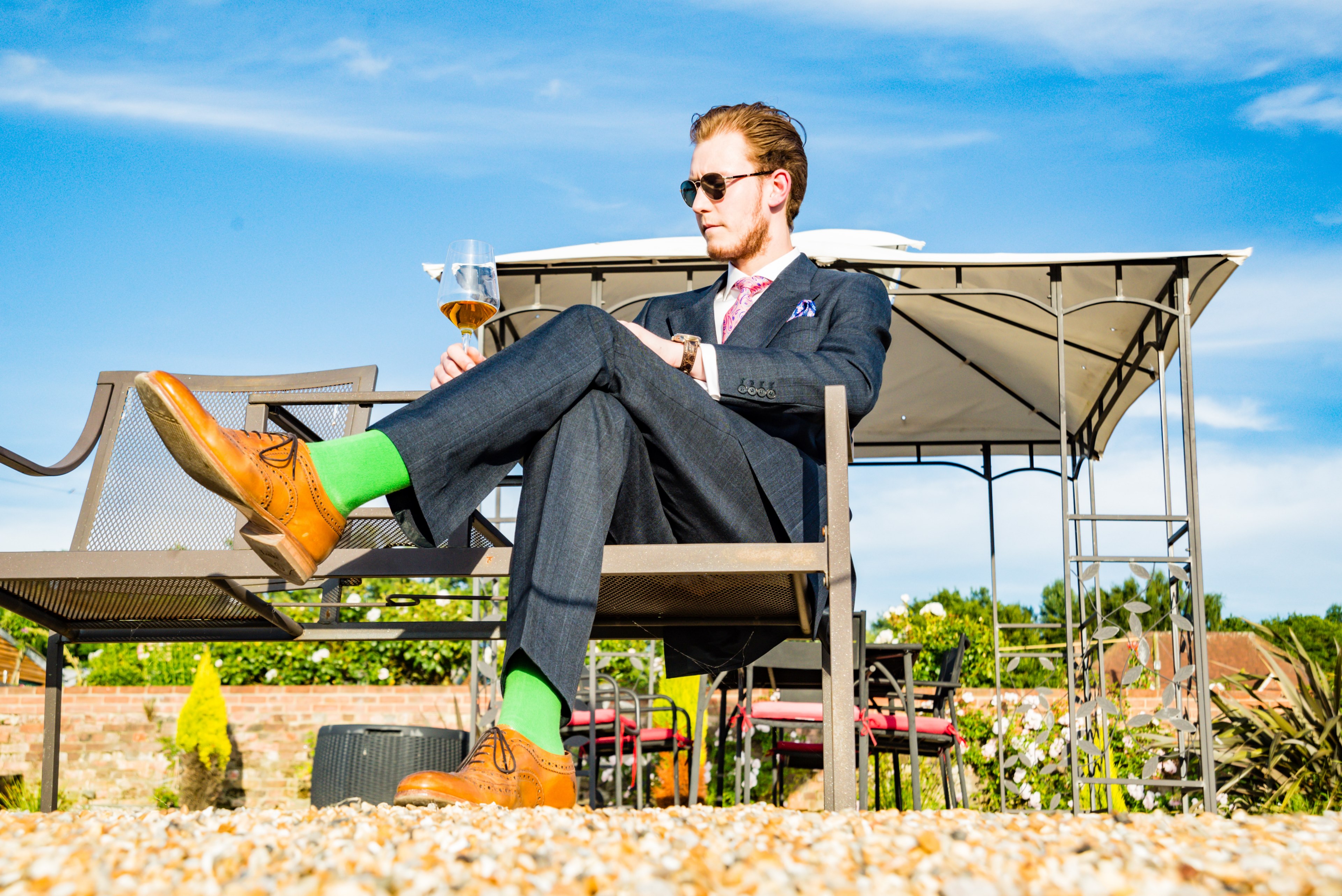 a man in sunglasses and a formal suit sitting on a bench outdoors with a glass of wine in his hand, elegant man with a wine glass 4k, HD Wallpaper