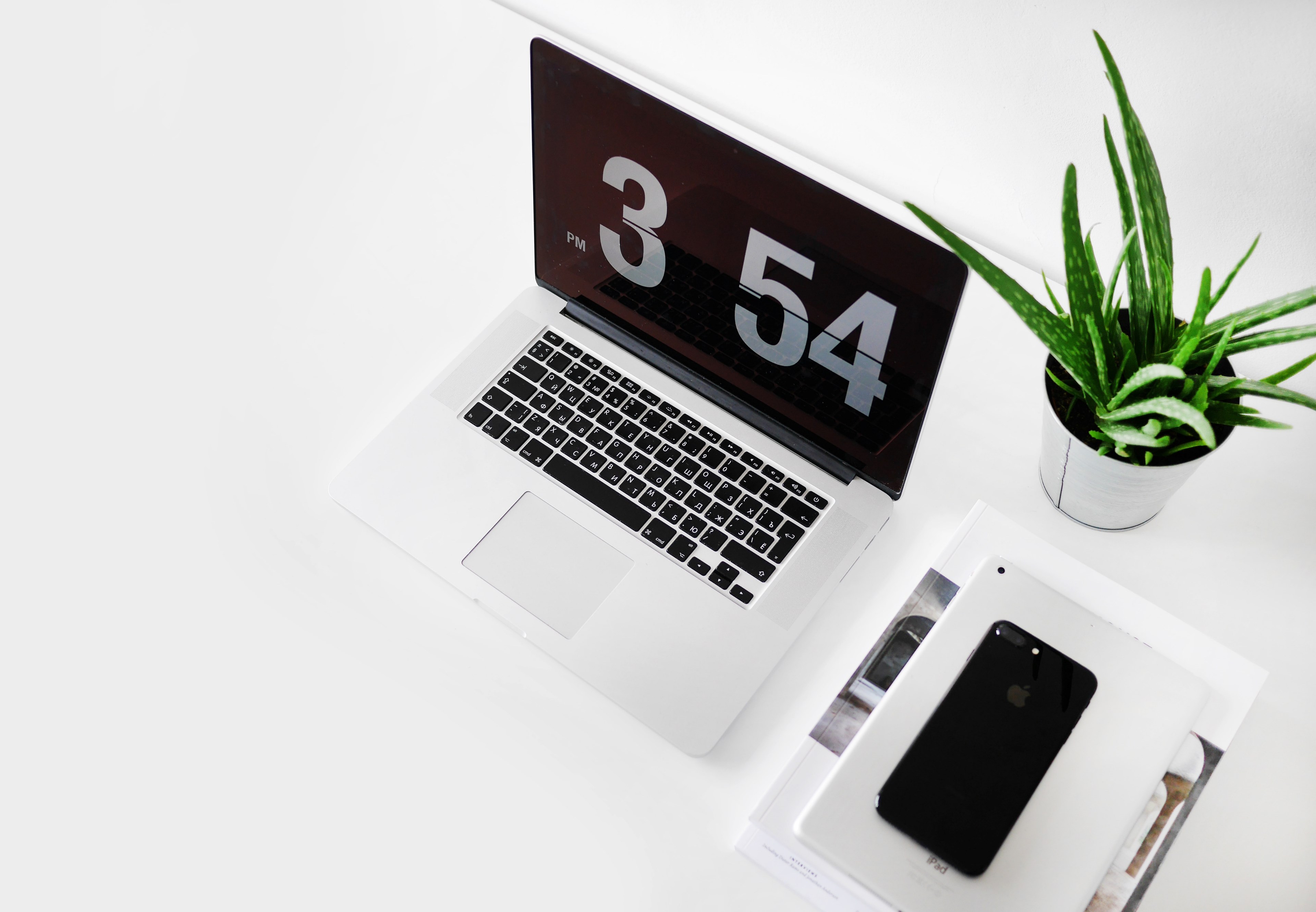 an iphone an ipad and a macbook on a desk with a potted plant, macbook laptop with time 4k, HD Wallpaper