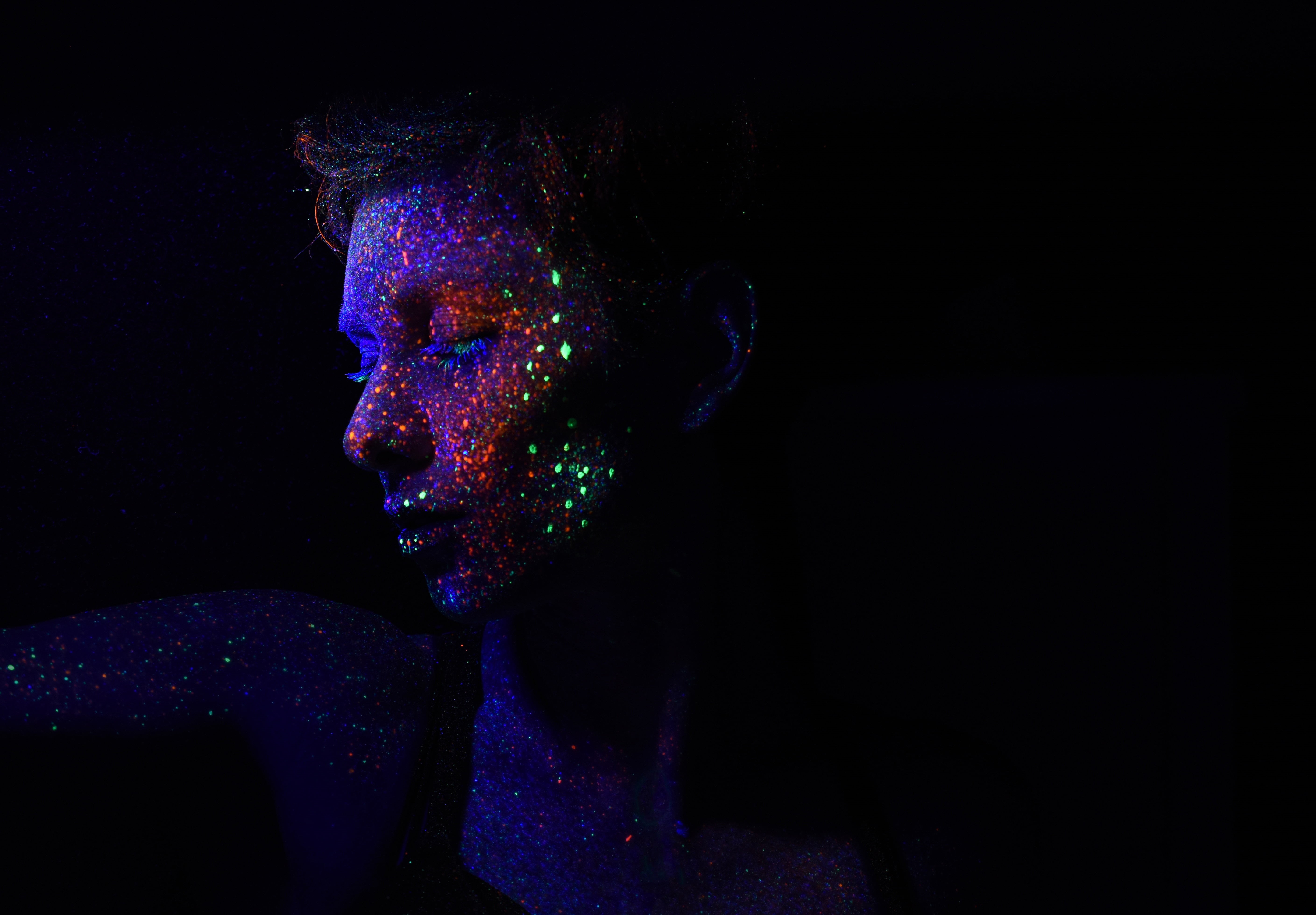 dark, glow, hairstyle, headshot, portrait, indoors, black background, close-up, face, copy space, multi colored, 5K, young adult, sequins, paint, face paint, HD Wallpaper