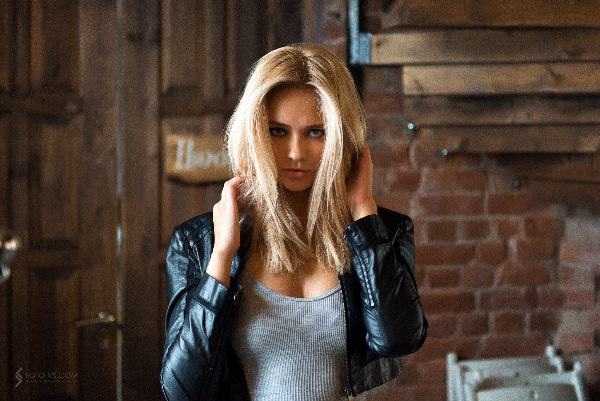 touching hair, grey tops, women indoors, leather jackets, women, 1080P, portrait, blue eyes, tanned, black jackets, long hair, blonde, HD Wallpaper