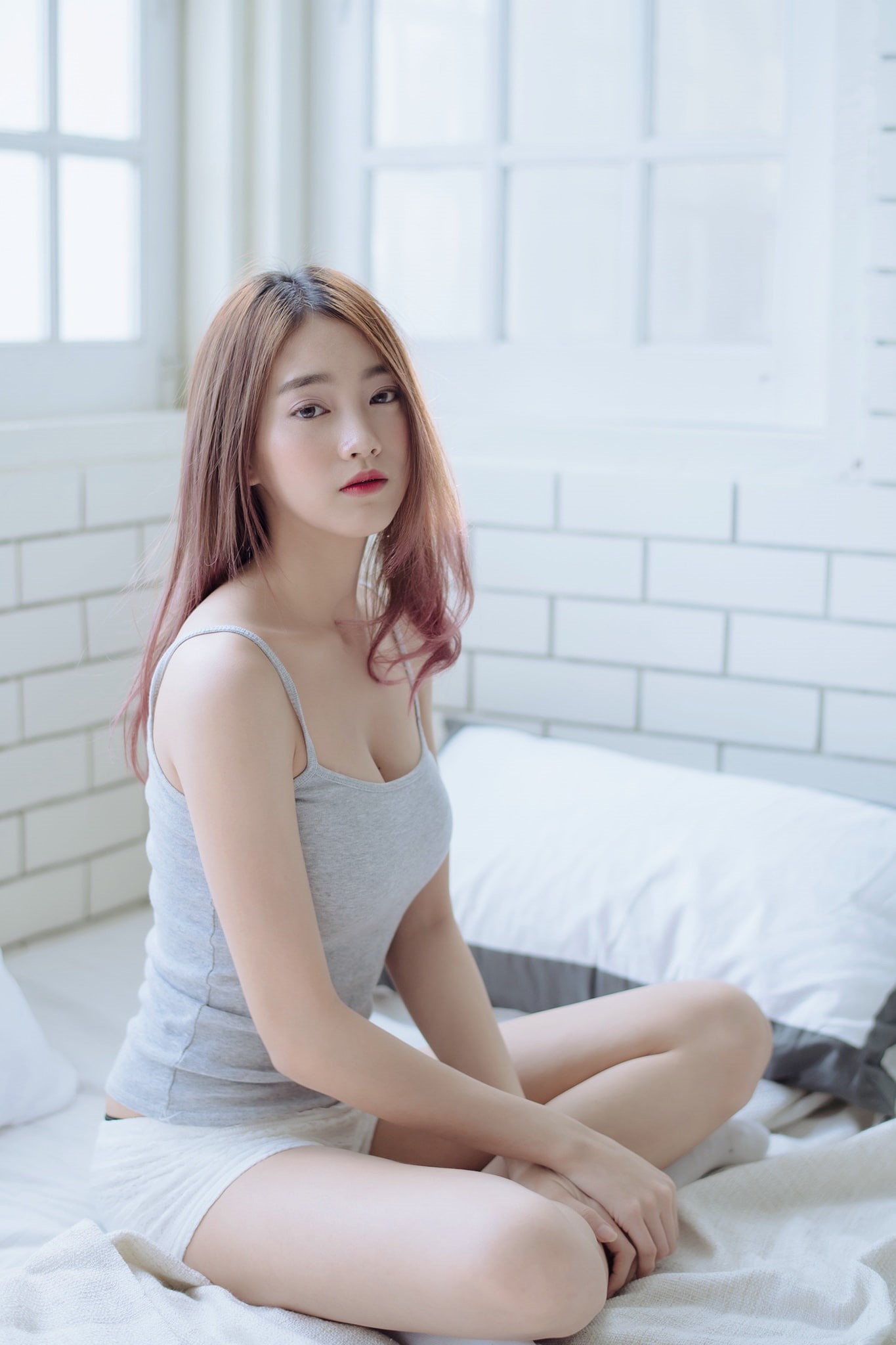 bedroom, short shorts, bed, Asian, legs crossed, indoors, women indoors, looking at viewer, women, grey tops, 1080P, sitting, in bed, brunette, pillow, Phone HD Wallpaper