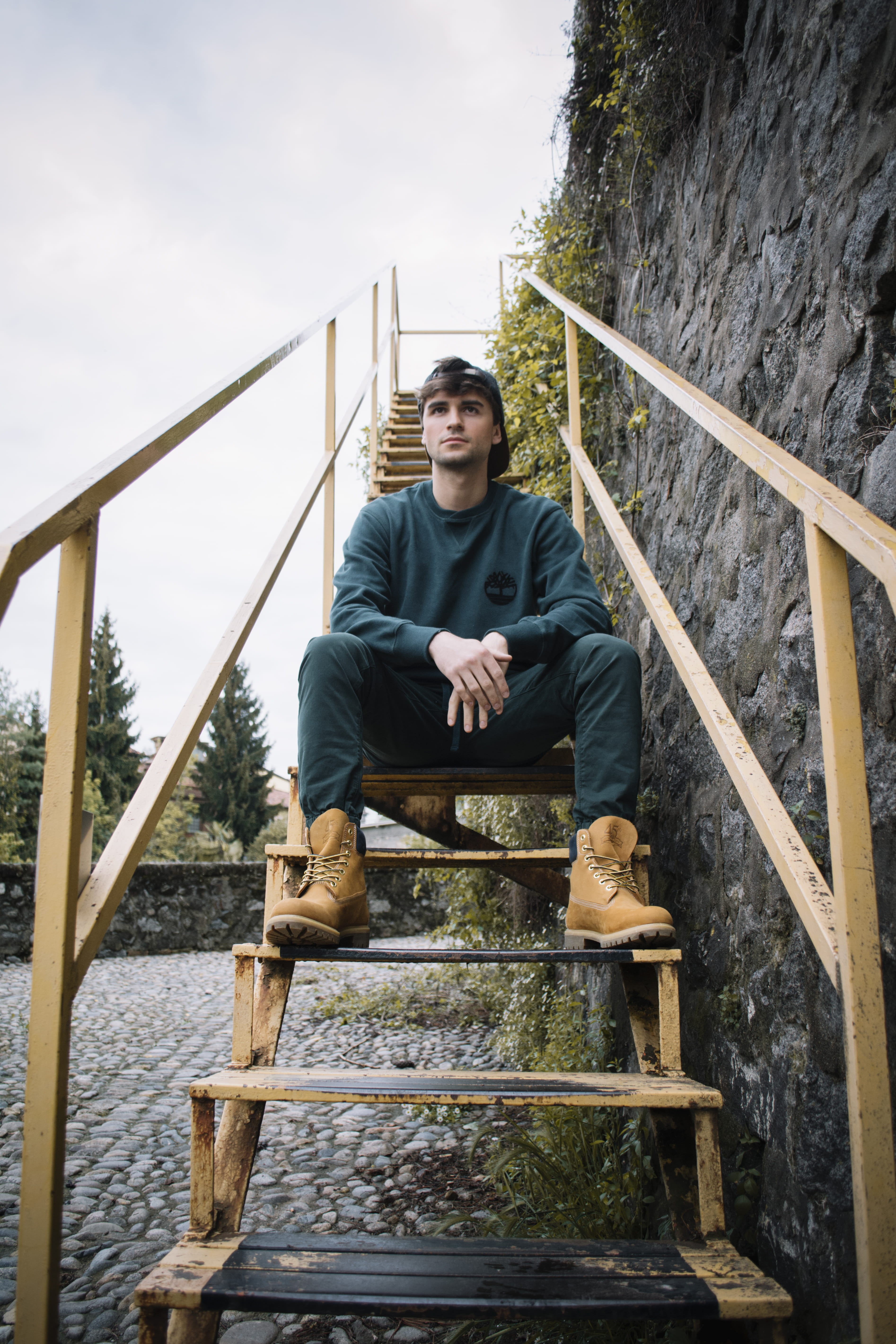 one person, stairs, footwear, sitting, casual clothing, steps and staircases, full length, young men, wood - material, boot, contemplation, apparel, real people, Phone HD Wallpaper