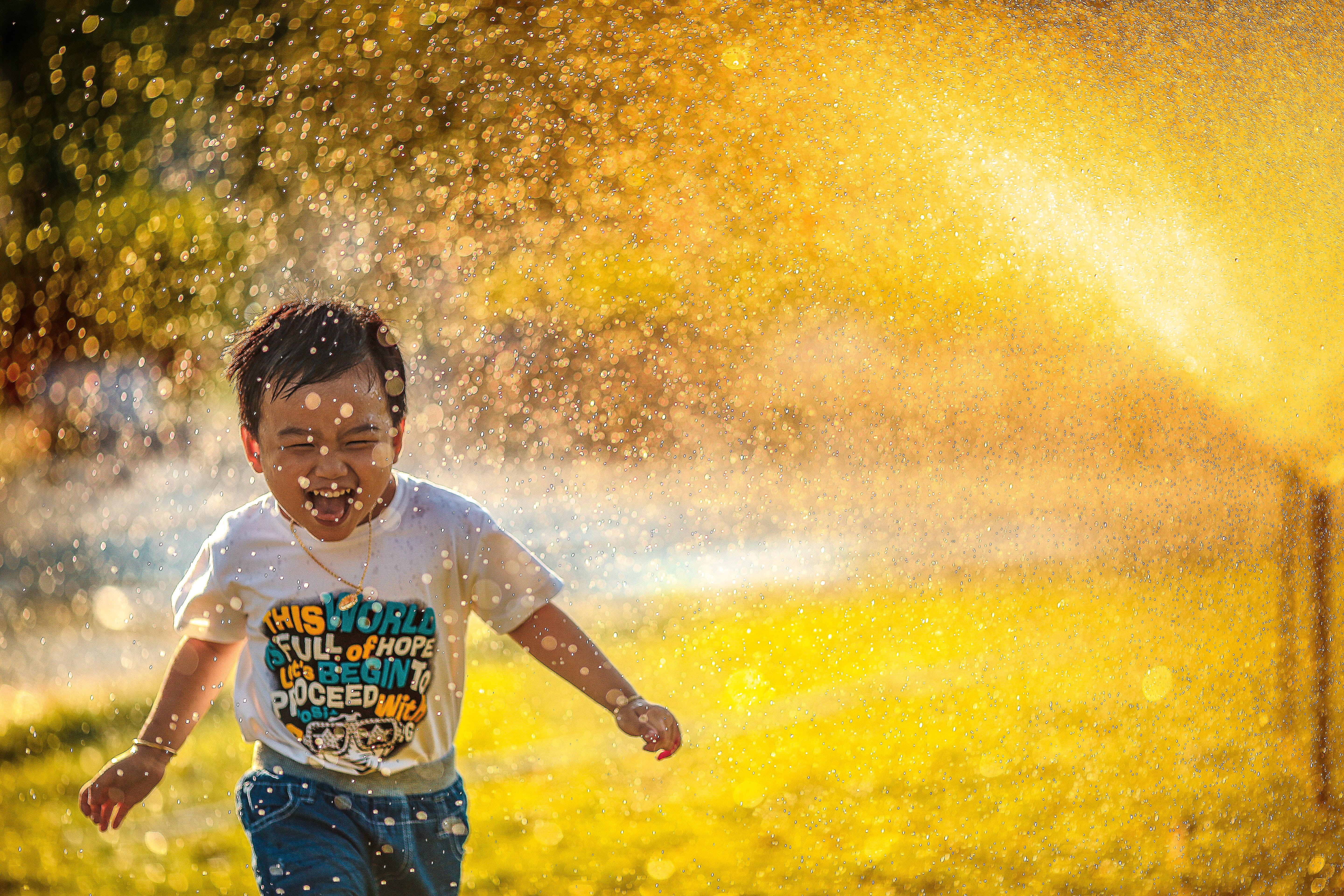 front view, 5K, males, running, outdoor, nature, wet, playing, water, motion, smiling, boys, green grass, playful, fun, boy, spraying, cheerful, one Person, HD Wallpaper
