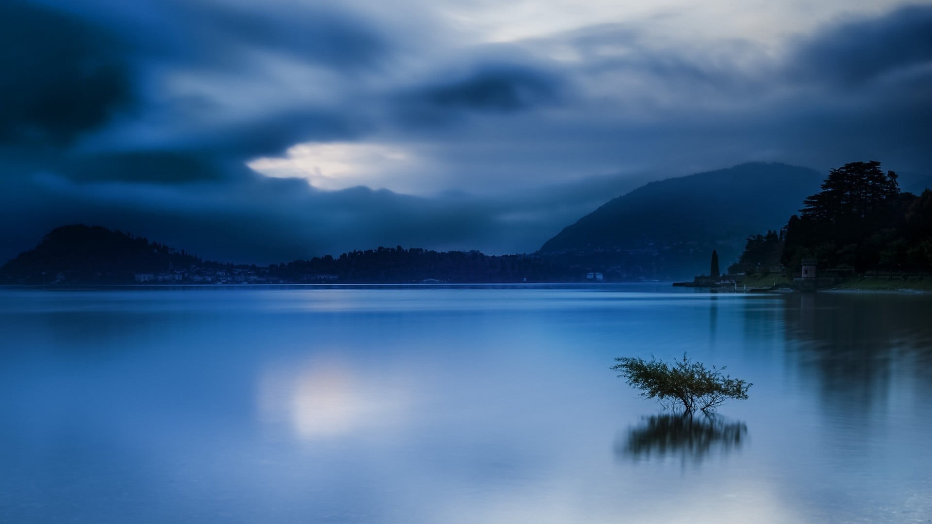 Italy, idyllic, beauty in nature, calm, water, blue, city, trees, tree, mountains, reflection, tranquil scene, storm, cloud - sky, landscape, 1080P, no people, HD Wallpaper