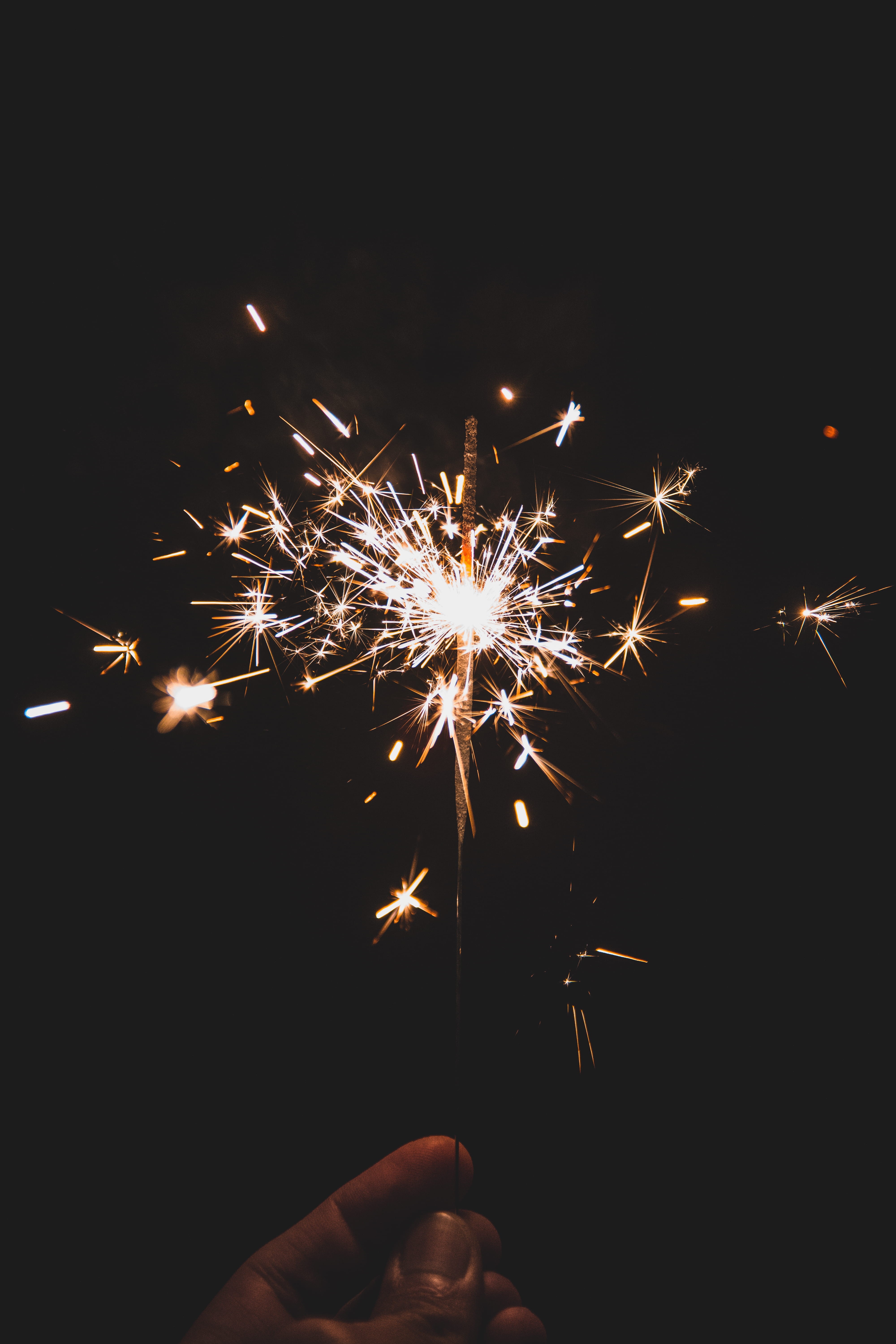 sparks, firework display, glowing, holding, glow, sparkler, 5K, firework, arts culture and entertainment, fireworks, fire, hand, motion, bokeh, one person, Phone HD Wallpaper