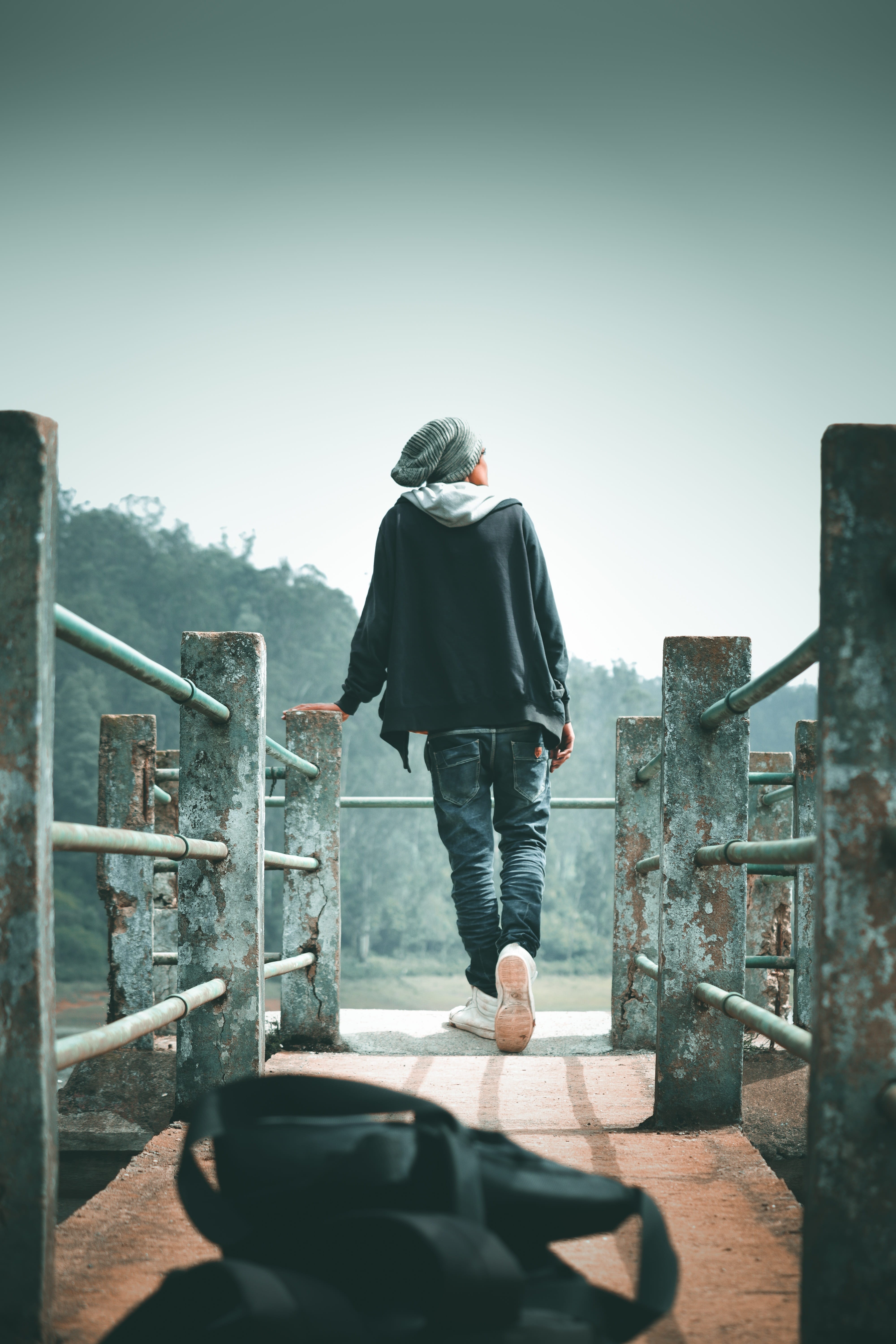 alone, clothing, day, lifestyles, real people, outdoors, clear sky, one person, standing, casual clothing, sky, looking at view, bridge, sunlight, built structure, Phone HD Wallpaper