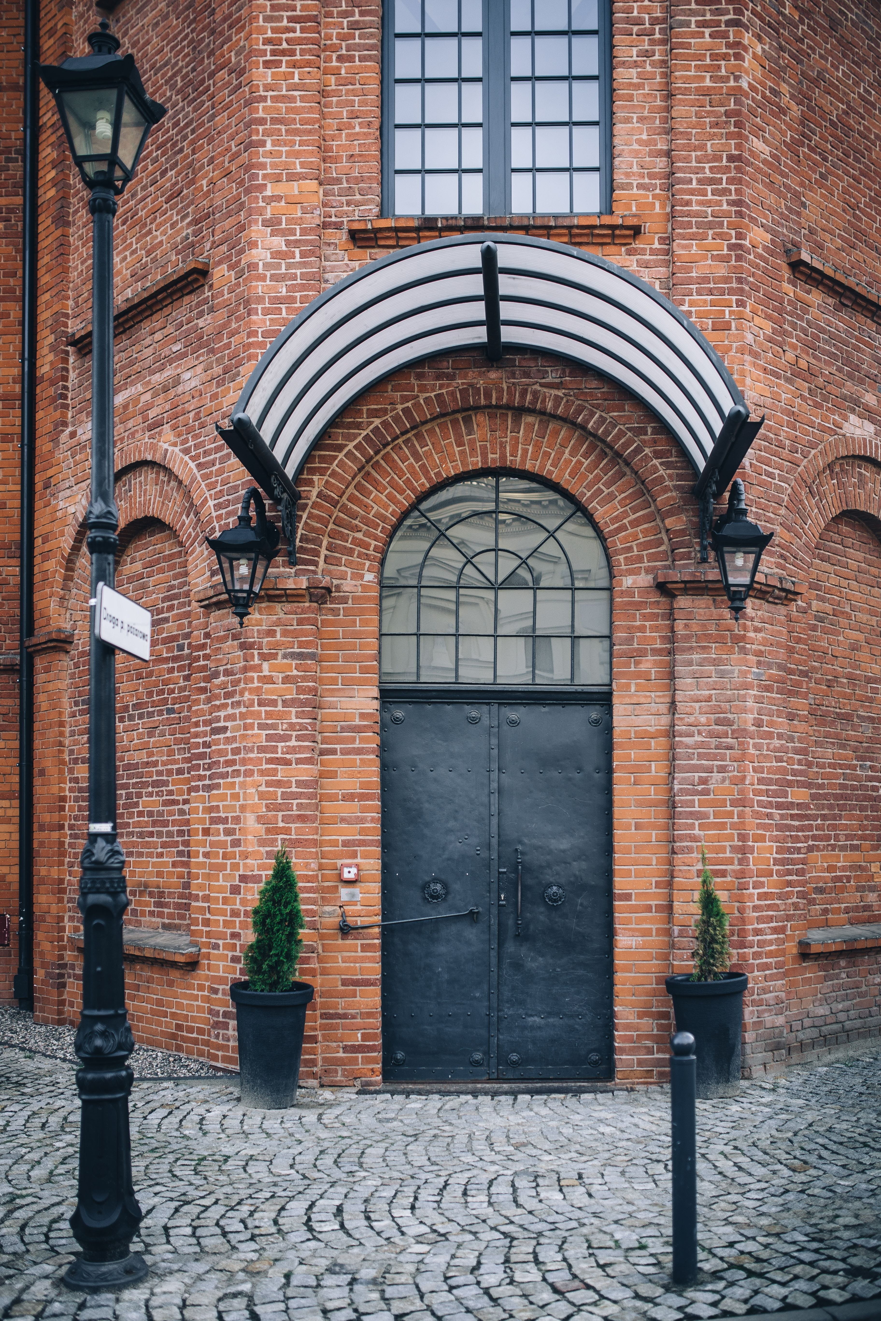 building Exterior, brick wall, building, day, built Structure, 5K, bricks, town, outdoors, buildings, arch, entrance, europe, closed, stone Material, Poland, Phone HD Wallpaper