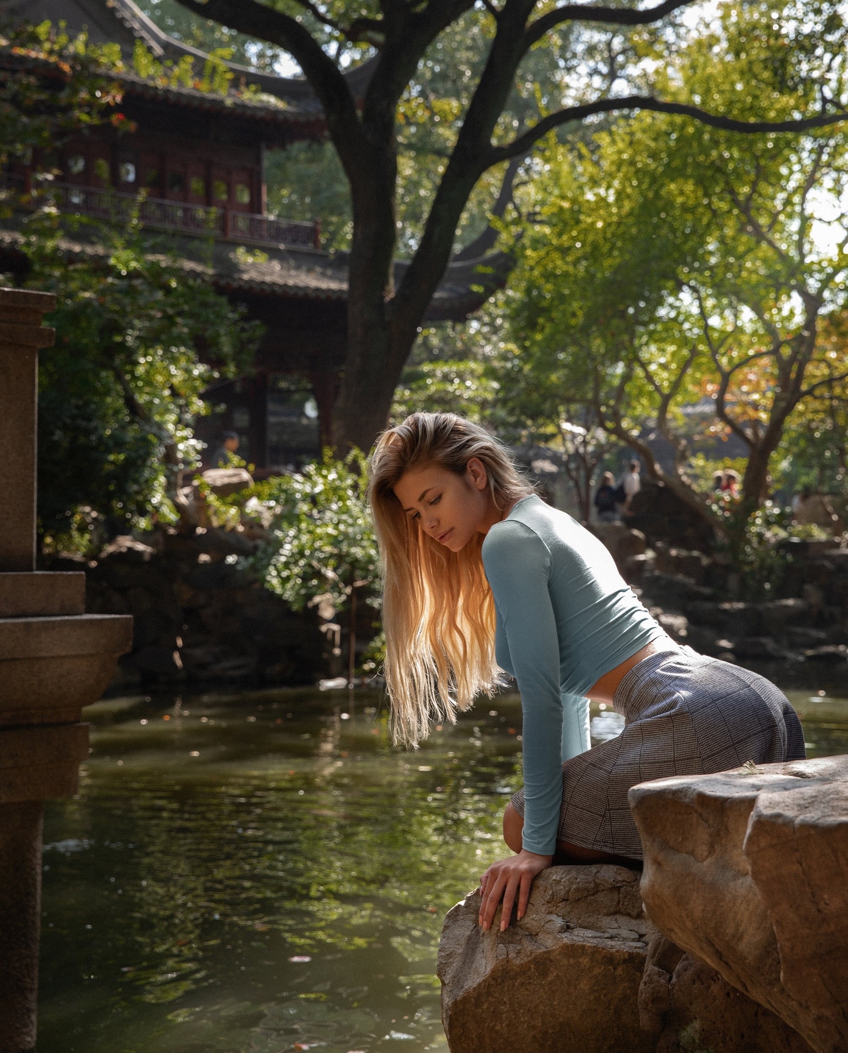 Asian architecture, long hair, Nata Lee, rocks, Aleksandr Mavrin, depth of field, water, 1080P, model, women, fountain, crop top, blonde, skirt, outdoors, Phone HD Wallpaper