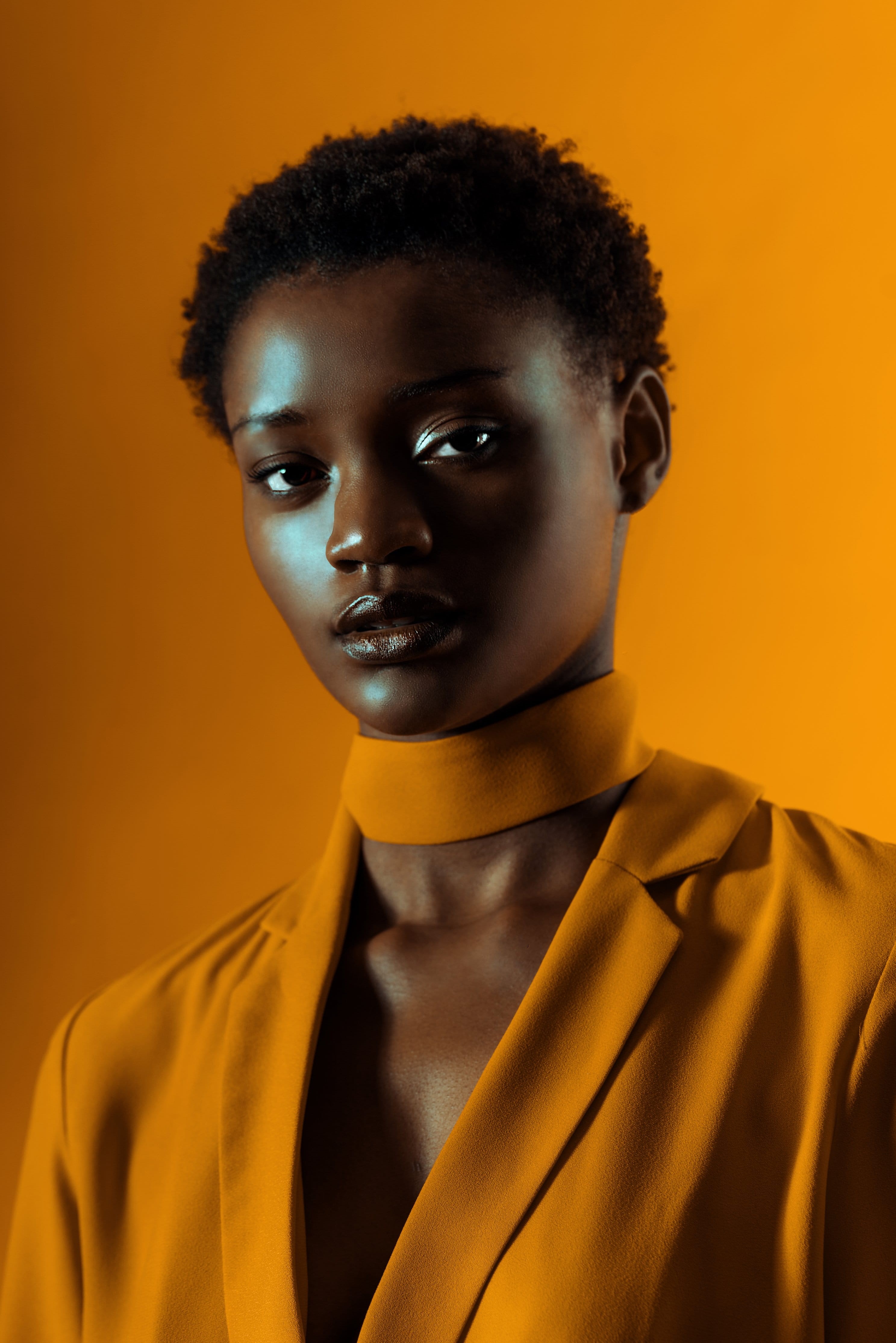 studio shot, serious, colored background, portrait, Emotion, looking at camera, close-up, indoors, yellow, hair, hairstyle, clothing, photo, orange background, Phone HD Wallpaper