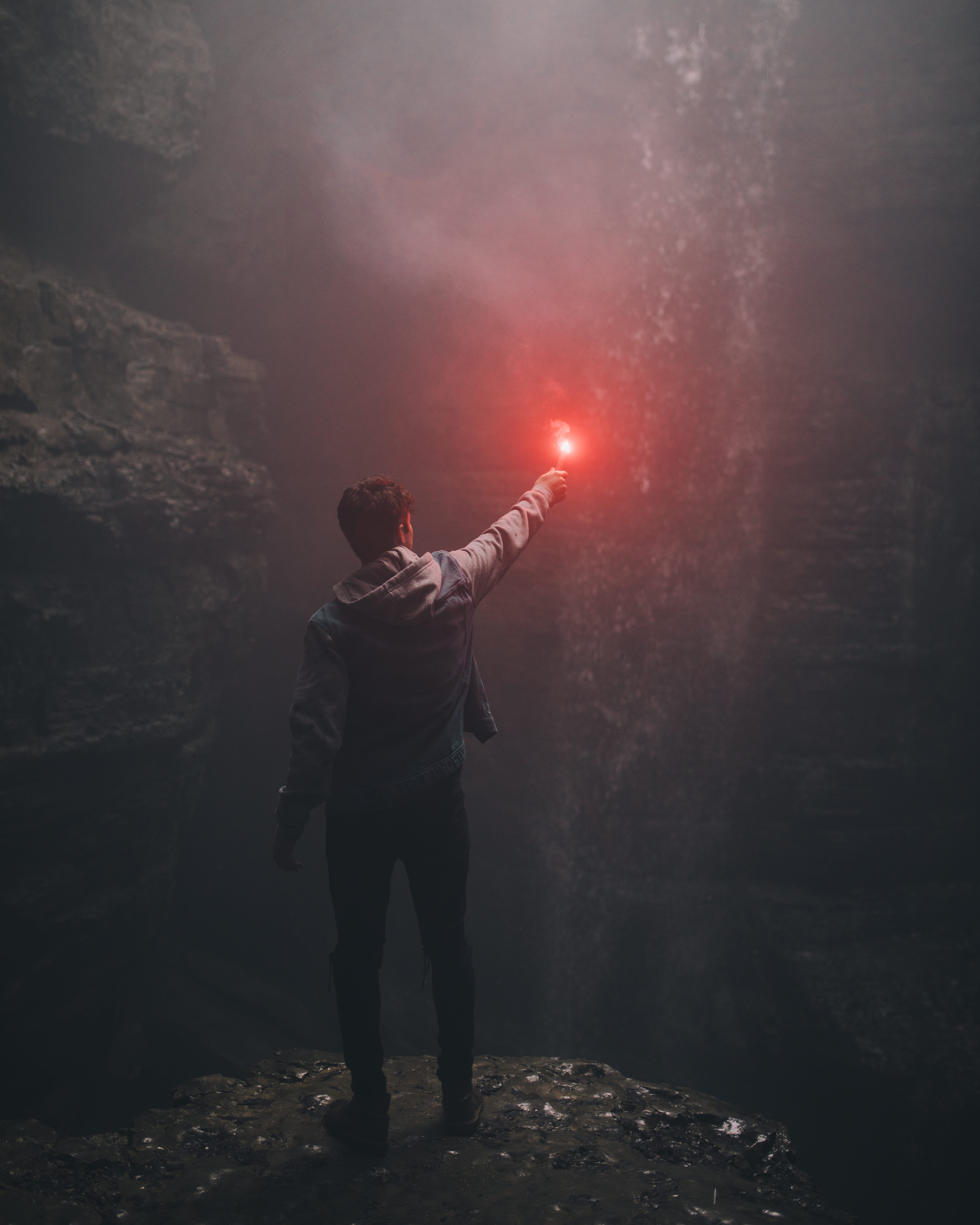 standing, cave, wall, holding, casual clothing, illuminated, digital composite, human limb, 5K, man, outdoors, adult, flare, limb, one person, smoke - physical structure, Phone HD Wallpaper