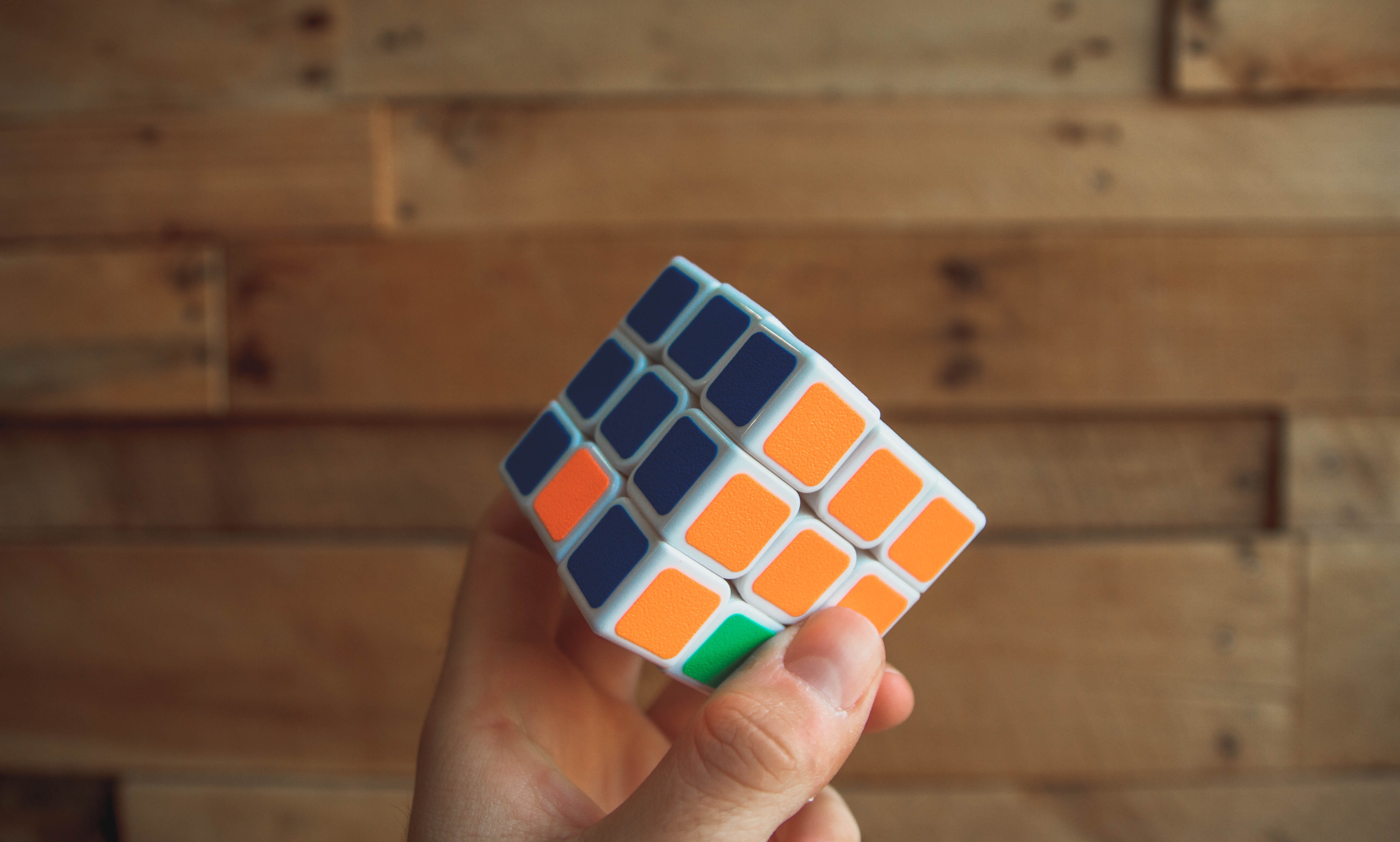 puzzle, playing, smart, pattern, gaming, rubik, shape, one person, relaxation, leisure games, las vegas, finger, hand, person, human hand, directly above, HD Wallpaper