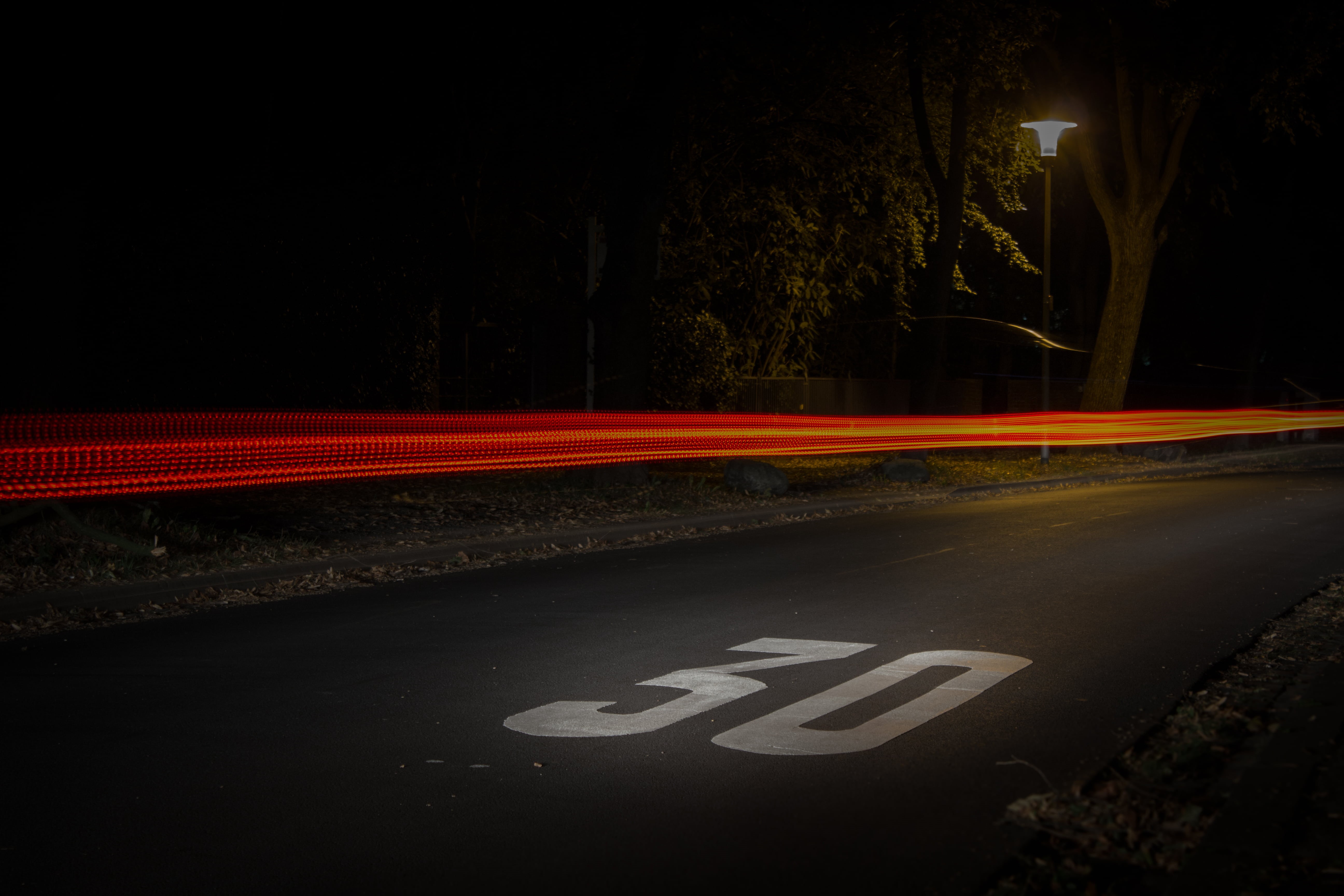 evening, park, blurred motion, road, illuminated, sign, speed, road sign, nature, light trail, lamp post, night, street, communication, turned, city, text, HD Wallpaper