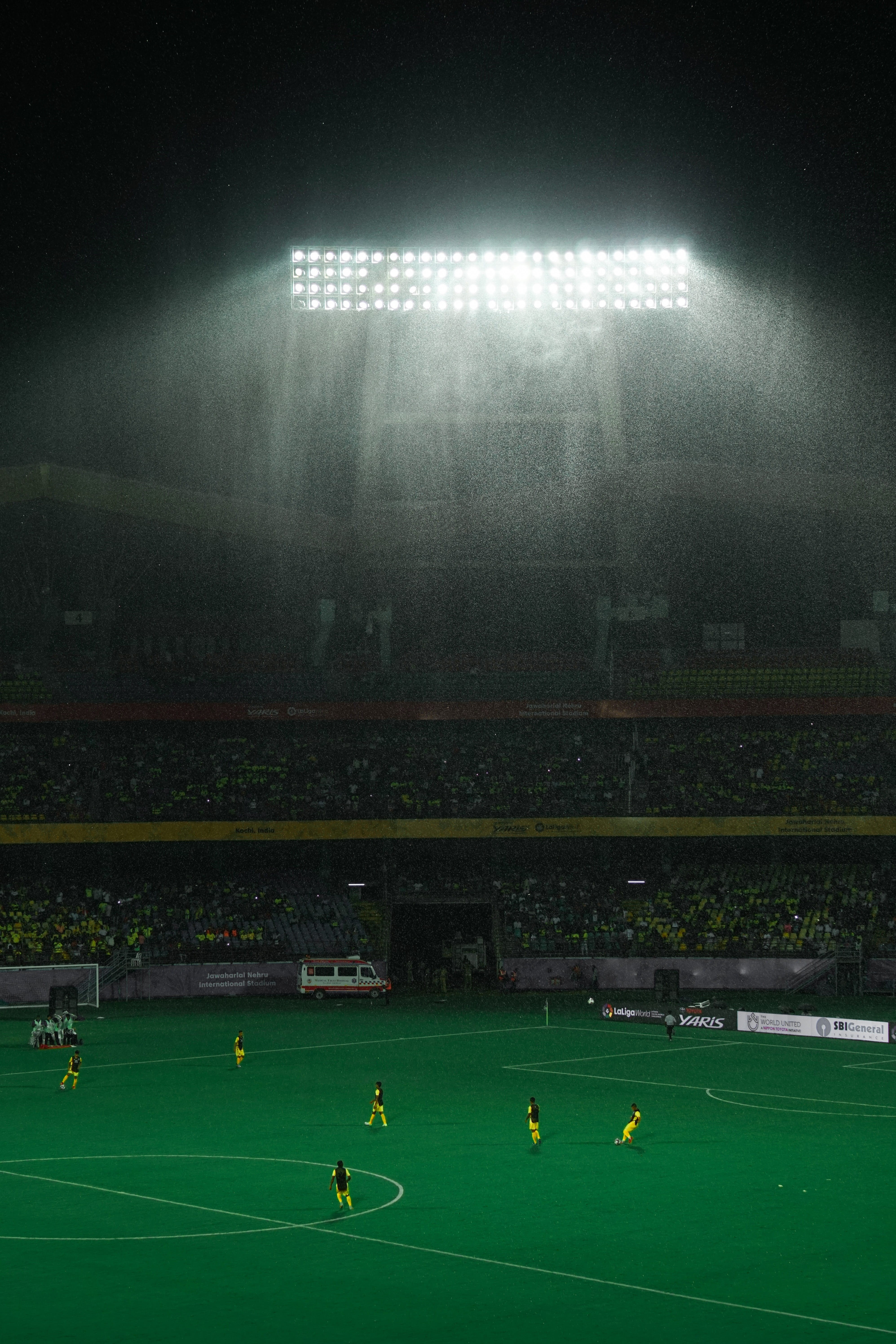 spectator, football, green color, illuminated, group of people, sky, 5K, grass, floodlit, soccer field, rain, sport, competition, real people, men, playing, Phone HD Wallpaper
