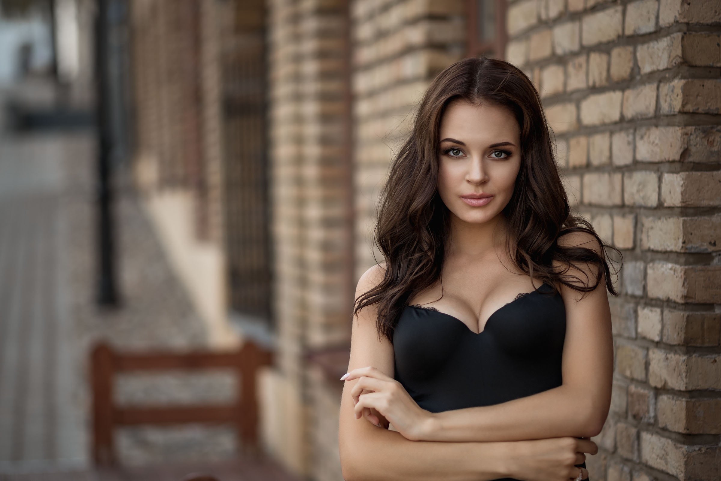 brick, looking at camera, black clothing, one person, hair, face, smiling, arms crossed, beautiful woman, architecture, 1080P, fashion, long hair, young adult, HD Wallpaper
