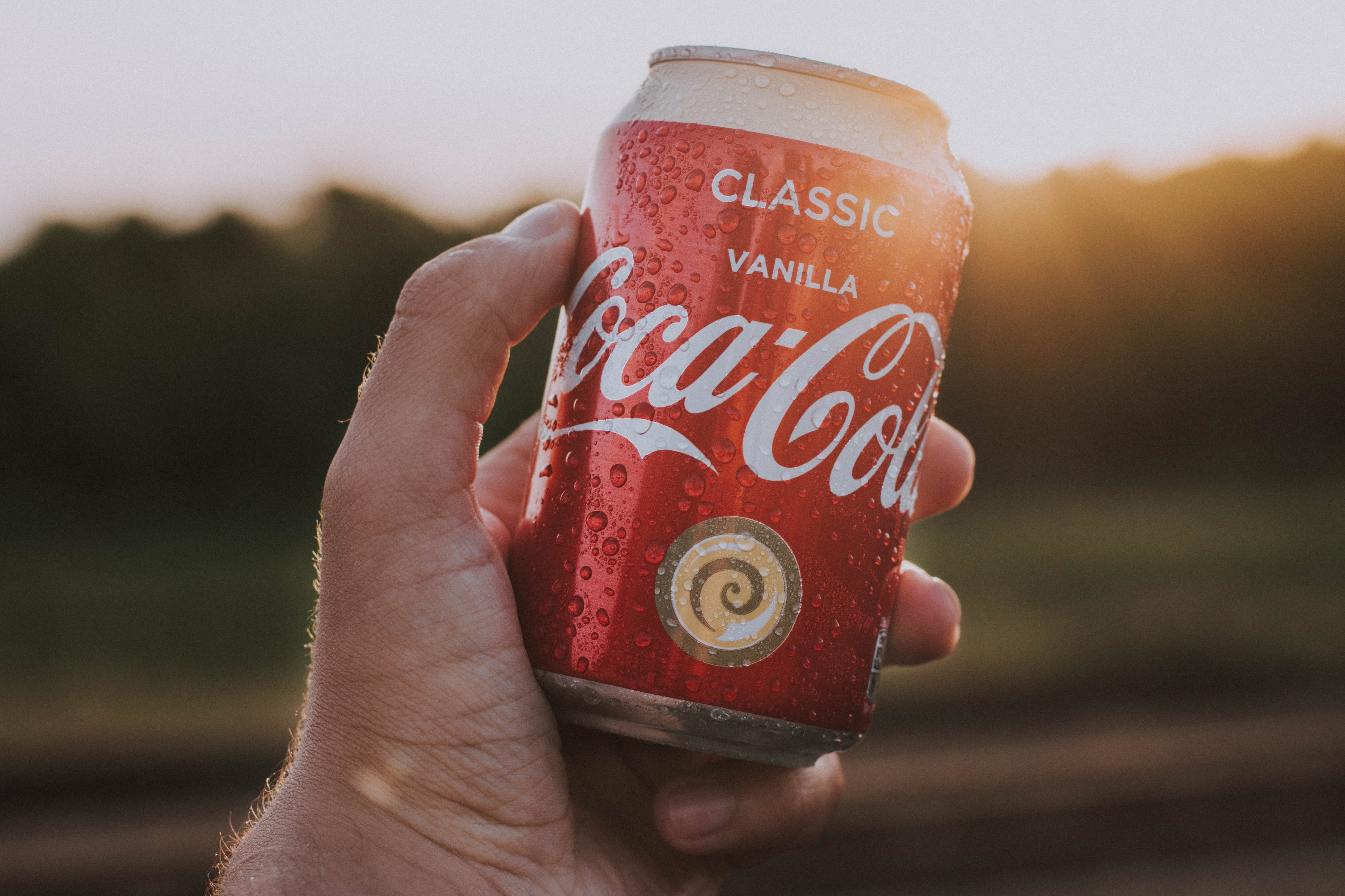 focus on foreground, coke, close-up, coca cola, classic, nikon, holding, cola, finger, text, nature, cold drink, drink, communication, outdoors, sign, one person, HD Wallpaper