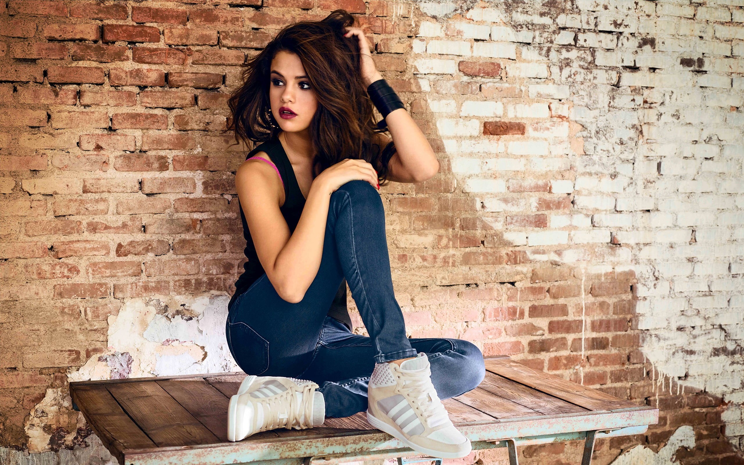 hair, hairstyle, beauty, Selena Gomez, actress, 2K, brick wall, young women, women, portrait, sitting, looking at camera, contemplation, jeans, one person, HD Wallpaper