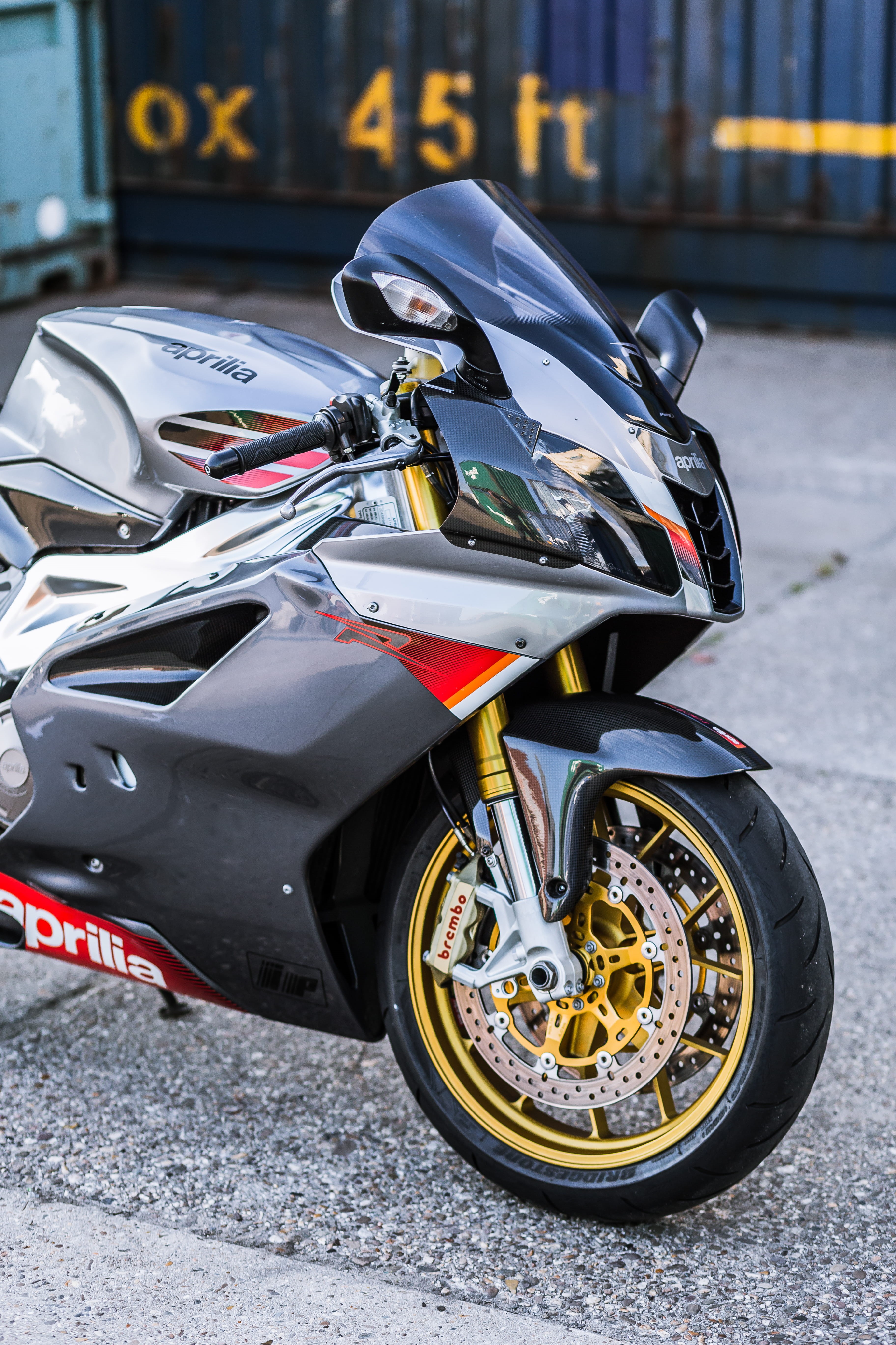 land vehicle, city, bike, sport, tire, street, sign, crash helmet, car, motor, superbike, day, motorcycle, motor vehicle, close-up, aprilia, stationary, Phone HD Wallpaper