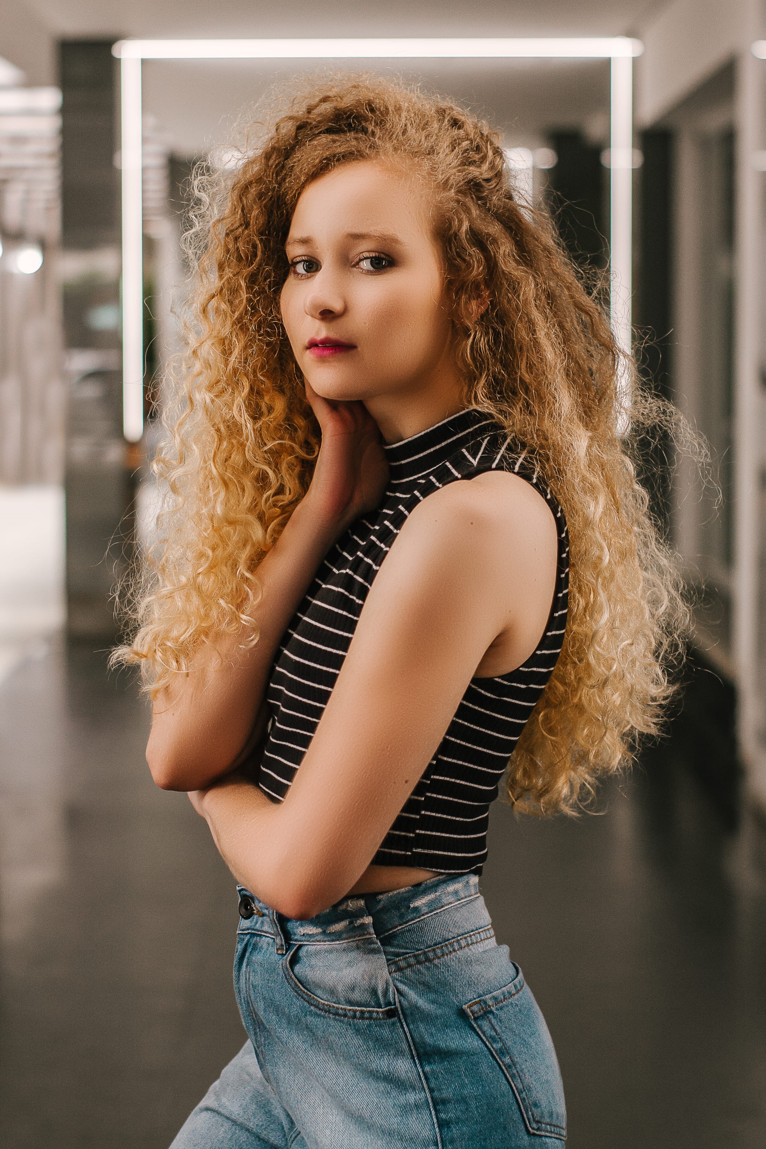 portrait, teenager, young women, posing, blue jeans, standing, curly hair, well, room, casual clothing, 2K, hair, long hair, young adult, lifestyles, blond hair, Phone HD Wallpaper