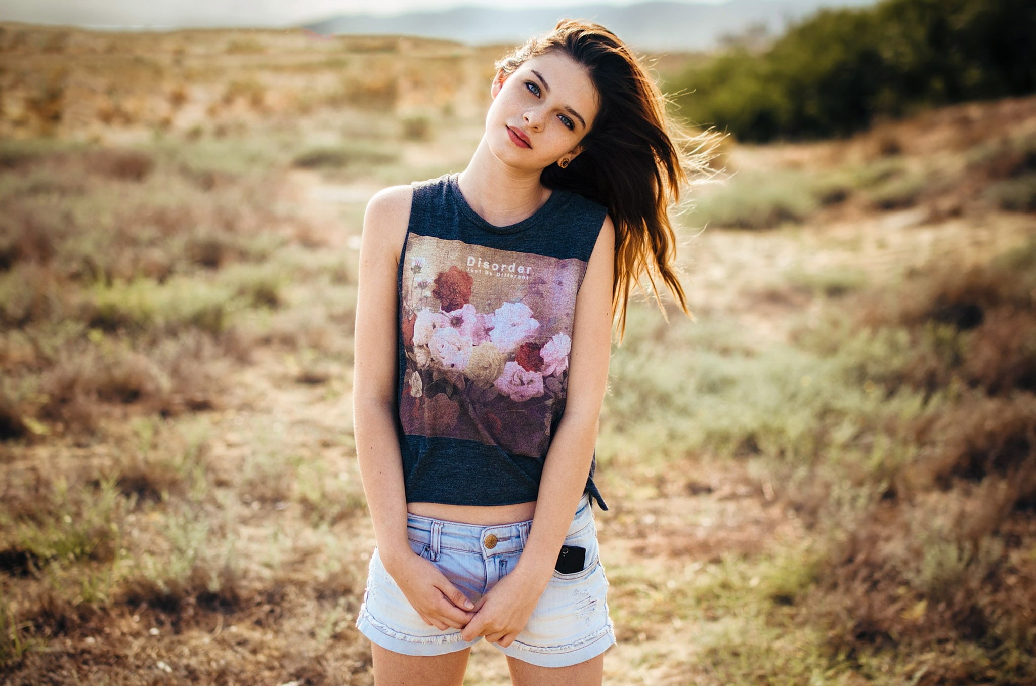 streched ears, 1080P, jean shorts, women, field, cellphone, portrait, women outdoors, model, belly, looking at viewer, freckles, depth of field, long hair, HD Wallpaper