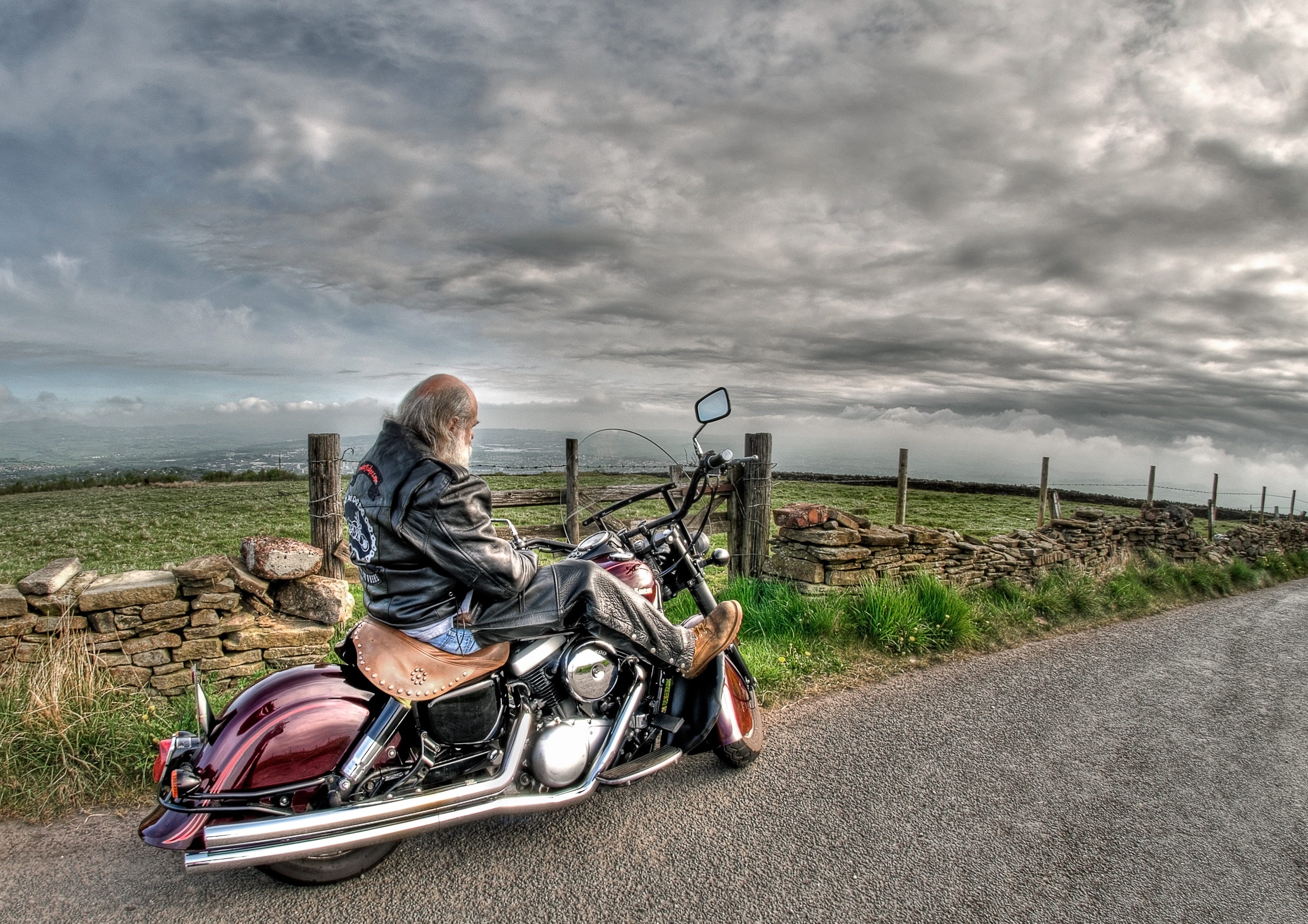 daytime, biker, cloud - sky, black, mature adult, sitting, adult, field, black leather jacket, man, vehicle, transportation system, cruiser, fence, ride, HD Wallpaper