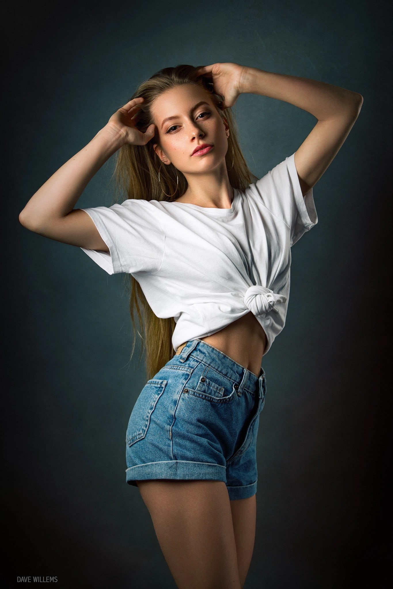 brunette, hands on head, women, high waisted short, Dave Willems, white shirt, belly, 1080P, looking at viewer, arms up, women indoors, Tied top, simple background, Phone HD Wallpaper