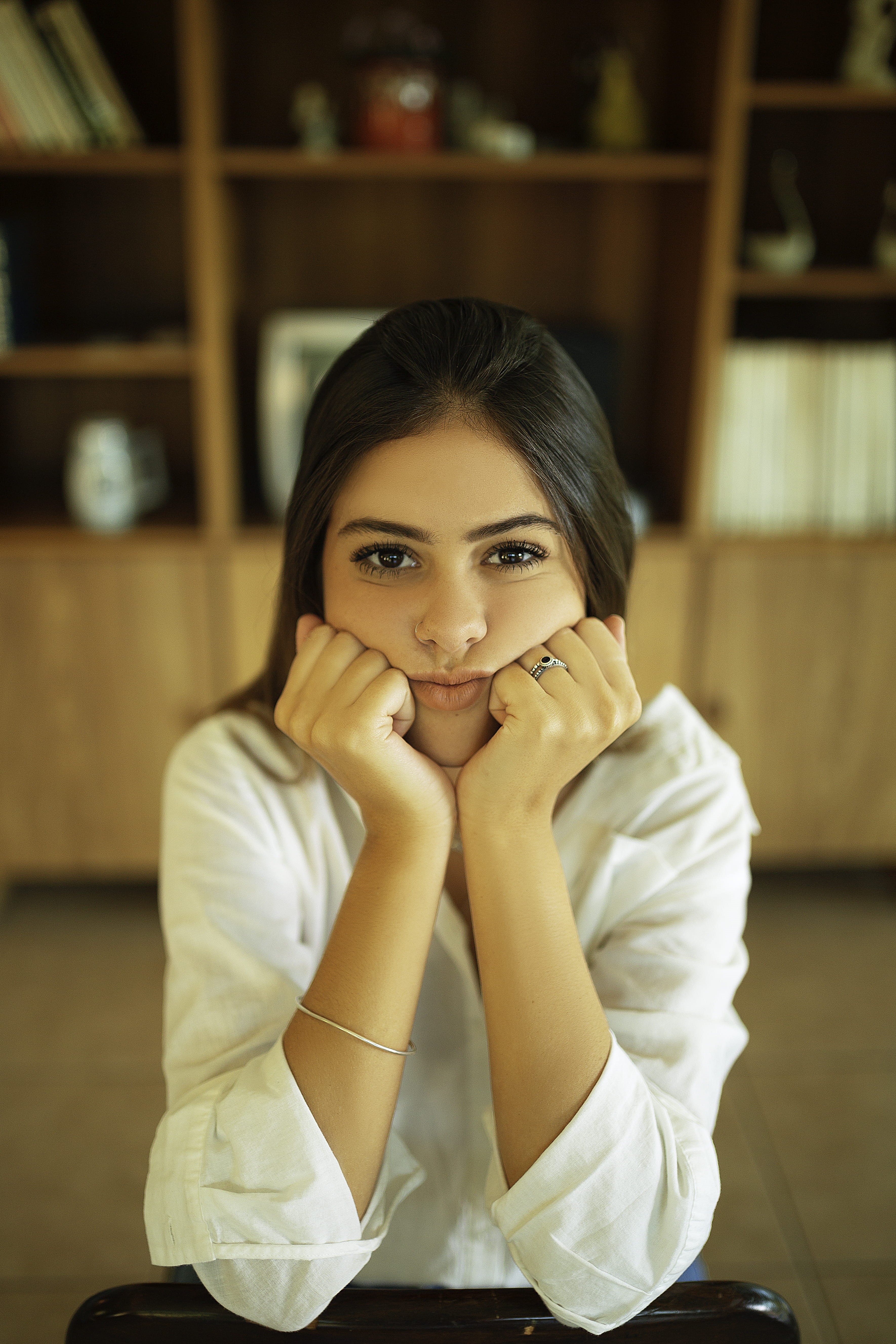 beautiful woman, indoors, hand, young adult, one person, lifestyles, sitting, real people, 5K, cute, adult, looking at camera, front view, looking, focus on foreground, Phone HD Wallpaper