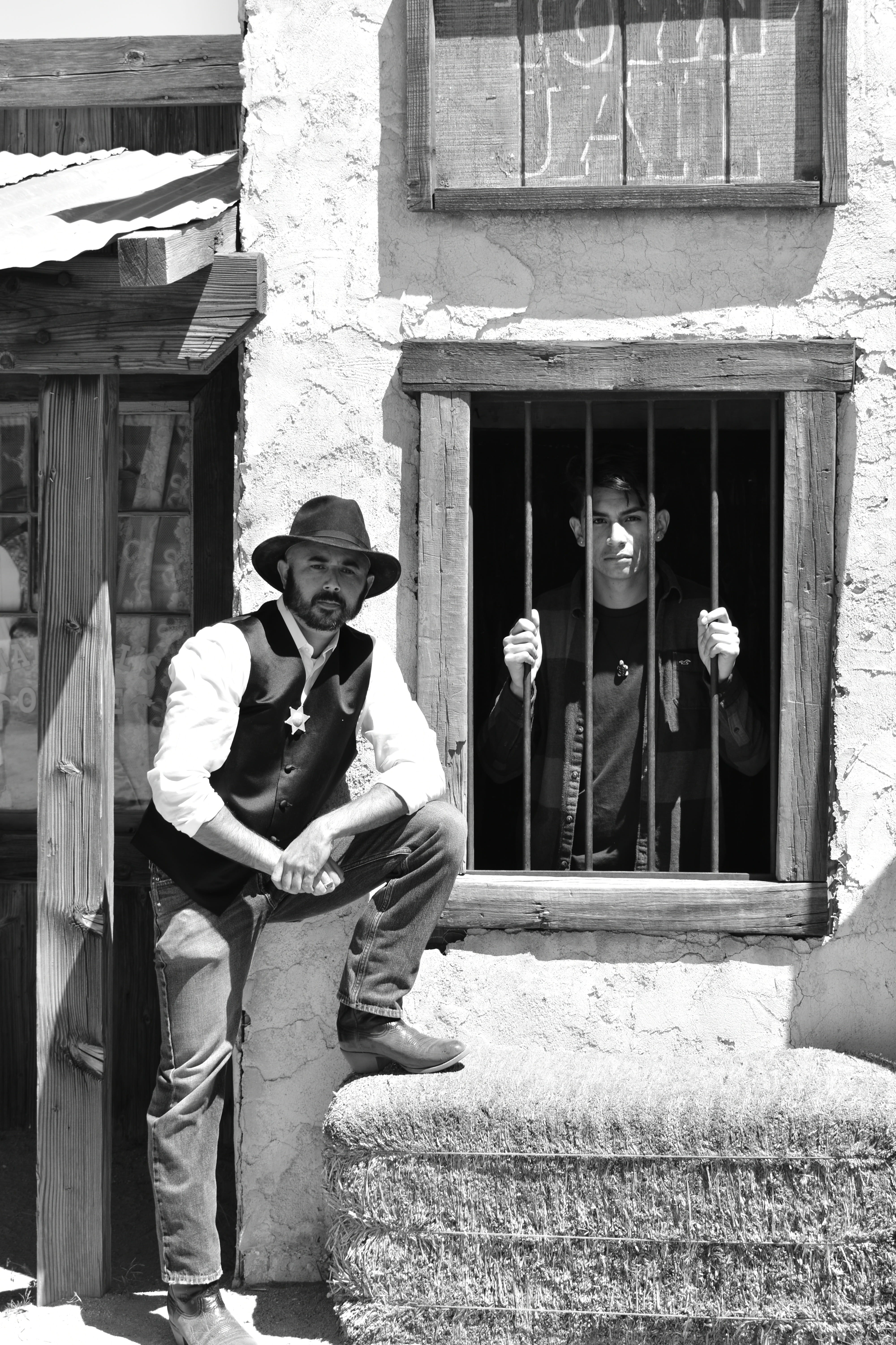 hat, young men, western, man, jail house, males, cowboy, wearing, west, sheriff, outdoors, building, black and white, full length, real people, wild, fedora, Phone HD Wallpaper