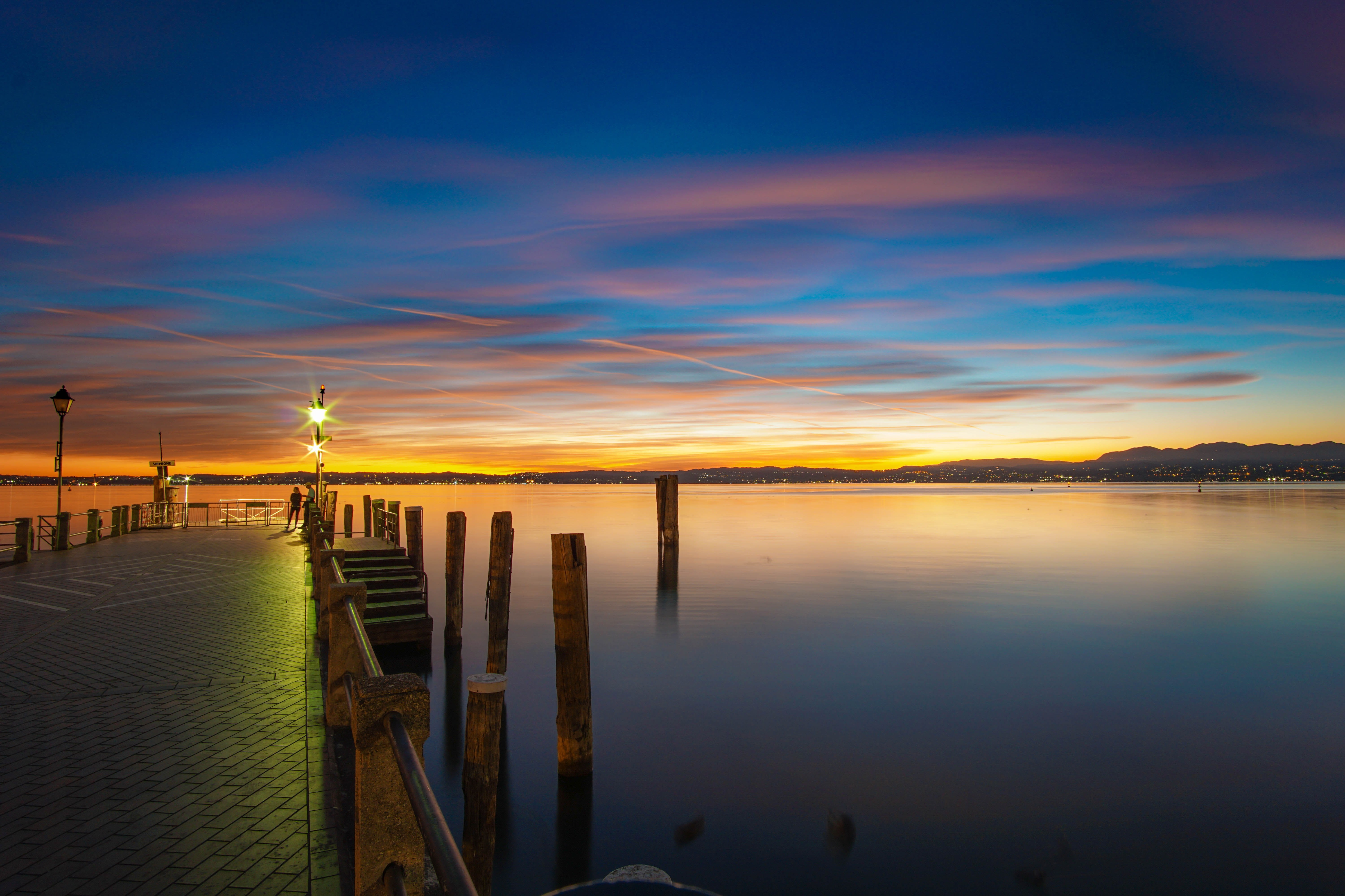 summer, orange color, reflection, sirmione, beach, non-urban scene, wooden post, pier, garda lake, blue, cloud - sky, tranquility, italy, scenics - nature, HD Wallpaper