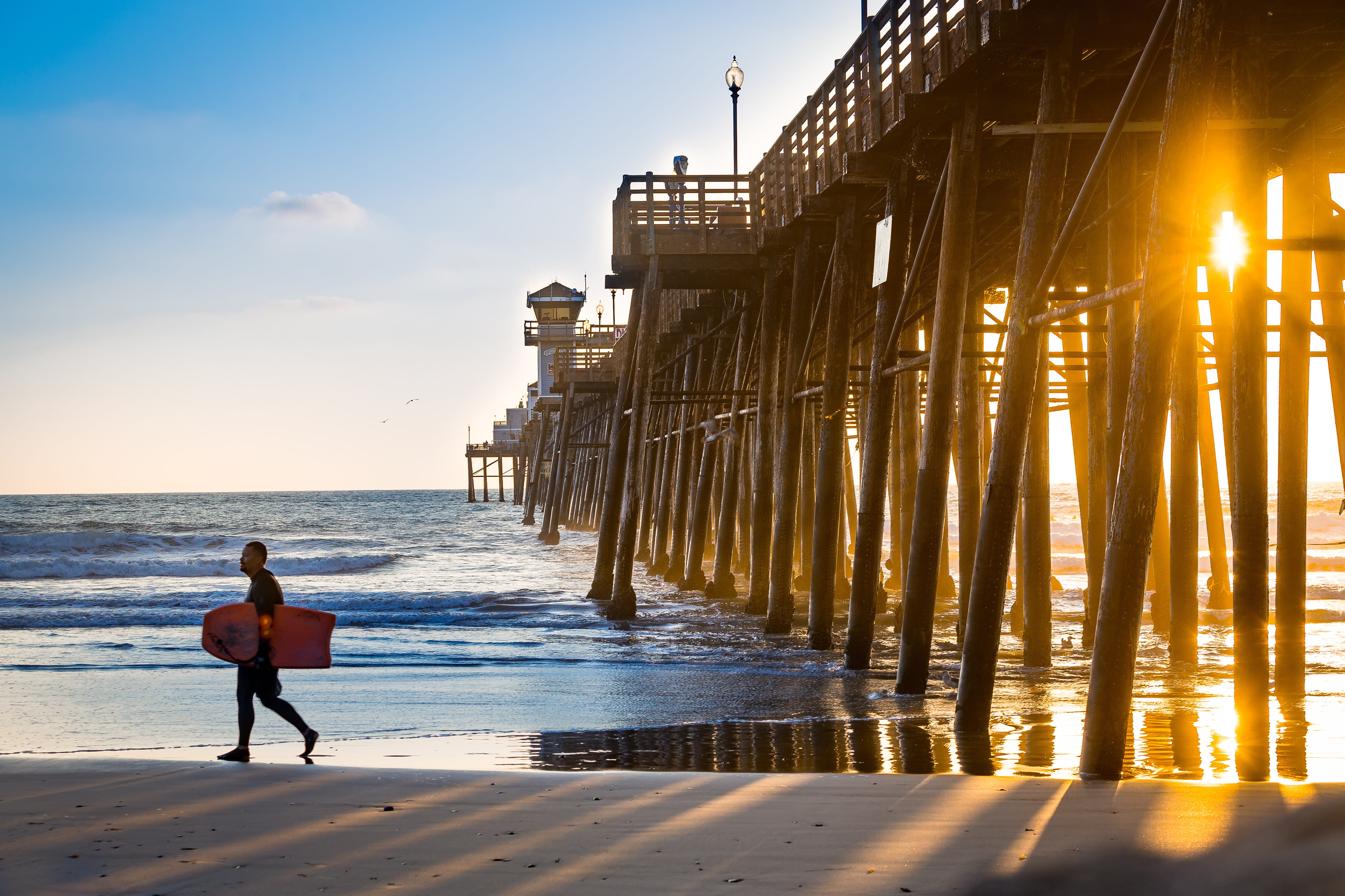 leisure activity, full length, sunset, golden, 5K, hour, sunlight, beach, one person, bodyboard, walking, built structure, architecture, carrying, outdoors, HD Wallpaper