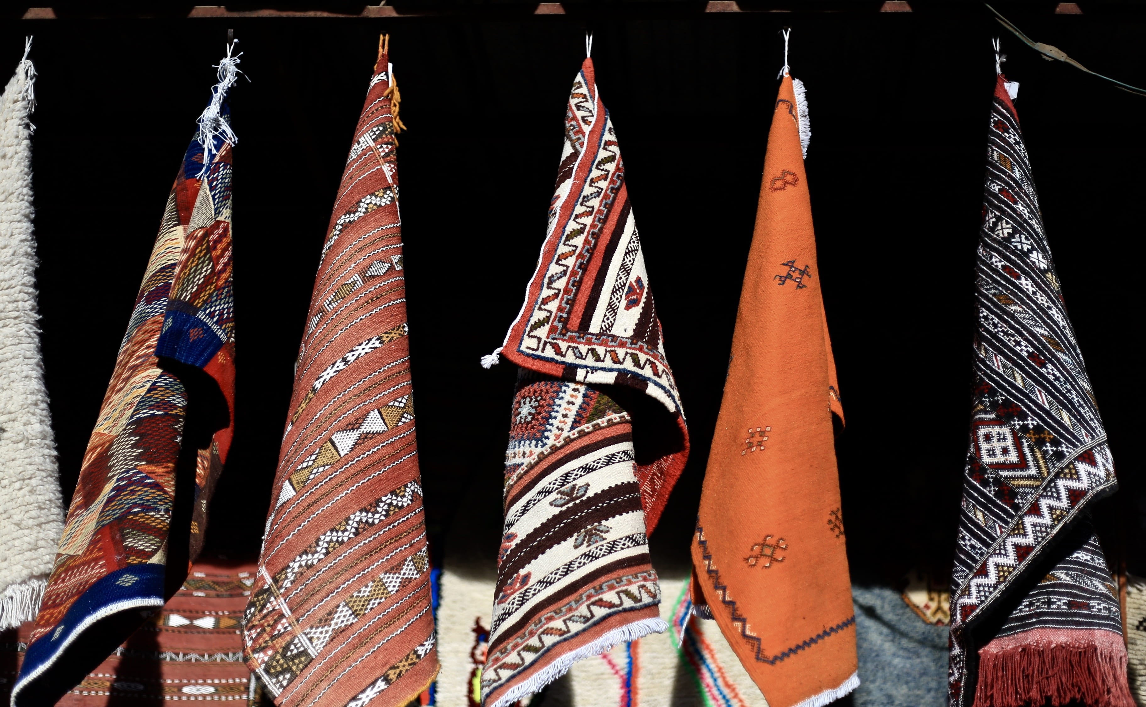 medina, sunlight, close-up, morocco, built structure, in a row, multi colored, creativity, side by side, pattern, for sale, textile, 2K, hanging, carpets, HD Wallpaper