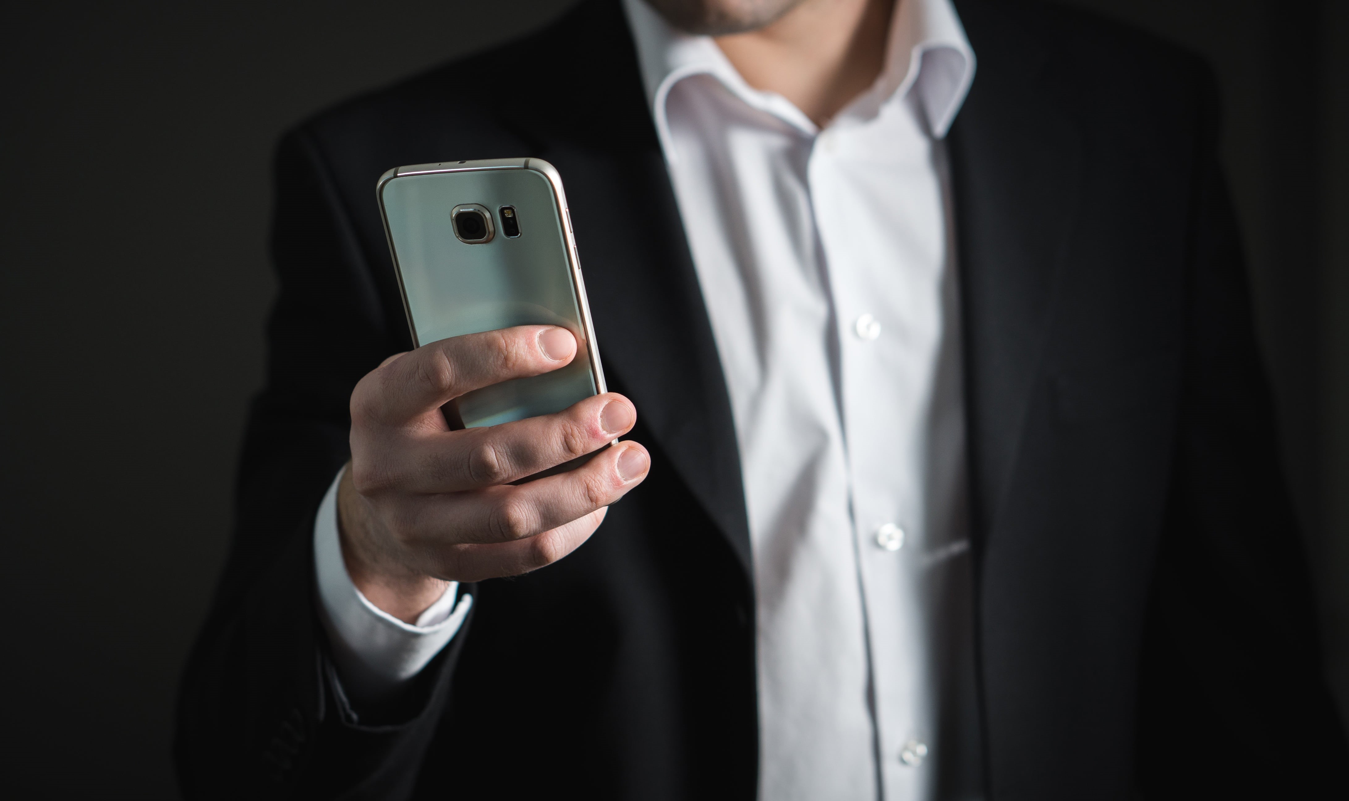 smart phone, businessman, person, smartphone, marketing, 4K, black background, holding, men, silver, technology, indoors, suit, portable information device, HD Wallpaper