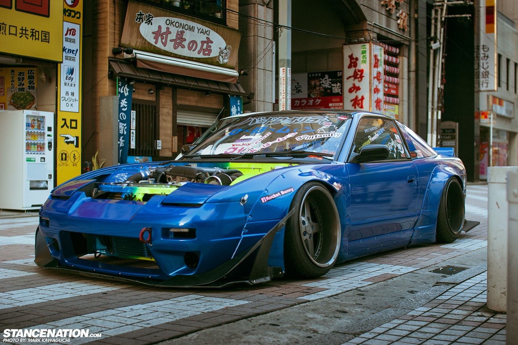 parking, building exterior, Rocket Bunny, city life, built structure, outdoors, mode of transportation, car, road, day, no people, architecture, text, 720P, HD Wallpaper